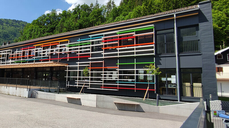 Vue latérale de la façade rénovée de l'école avec les Siding.X PREFA dans la teinte P.10 anthracite