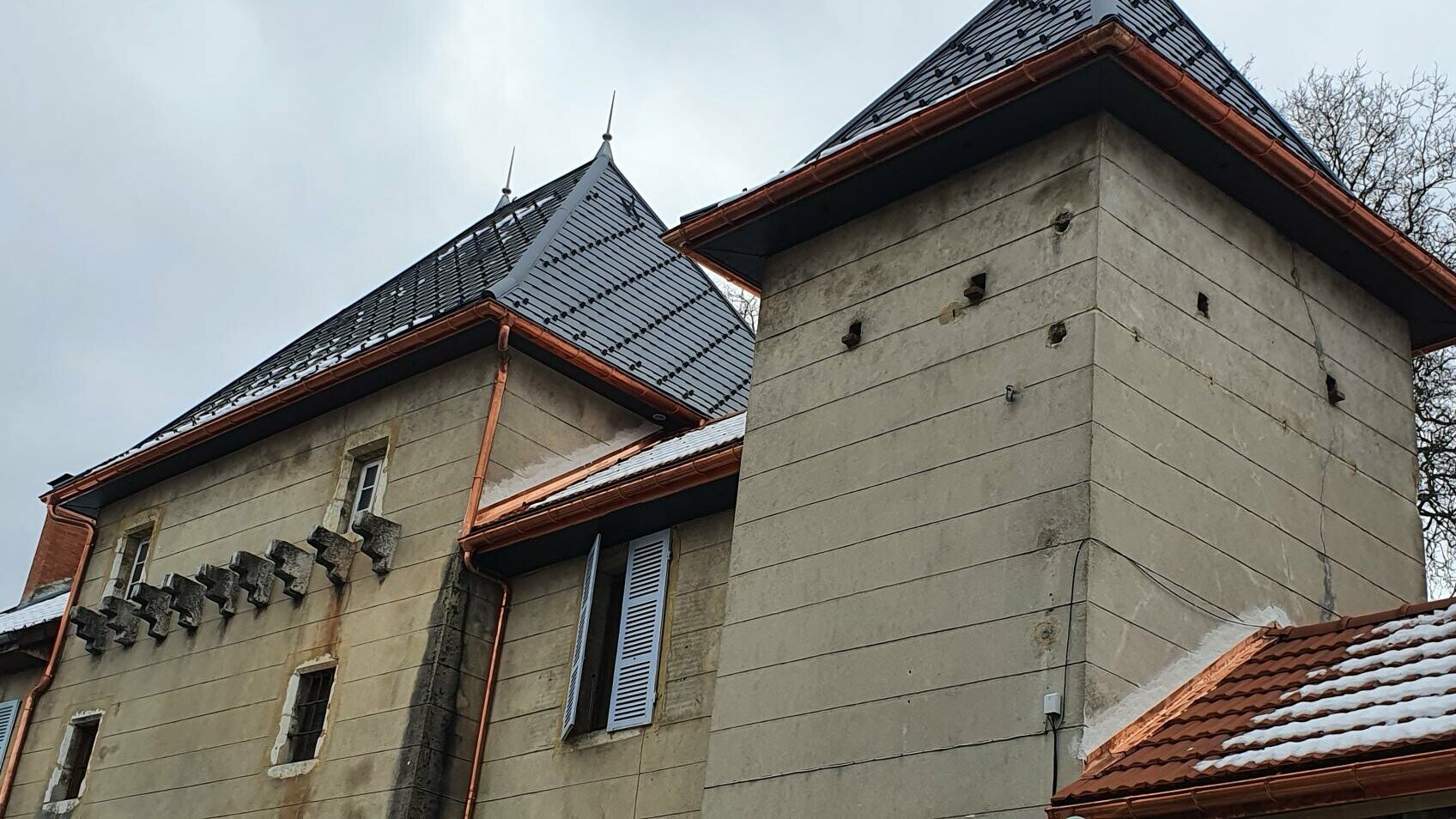 Zoom sur les tourelles dont la couverture est habillée de bardeaux PREFA teintes gris sombre