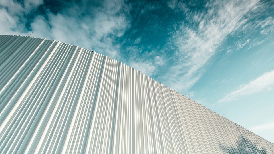 Une architecture à couper le souffle avec une façade en aluminium PREFA blanche dans le parc d’activités Walter Business Park près de Vienne. La façade, composée de profils extrudés sur mesure, crée grâce à son caractère ondulant et fluide un jeu fascinant d’ombre et de lumière. Trois formes de profils différentes apportent une profondeur exceptionnelle et confèrent au bâtiment une esthétique à la fois claire sur le plan stylistique et résolument dynamique. La surface PREFA, durable et résistante aux intempéries, associe une esthétique moderne à une perfection fonctionnelle – un véritable point fort de l’architecture de façade contemporaine, qui rend visibles la qualité architecturale et la sophistication technique.