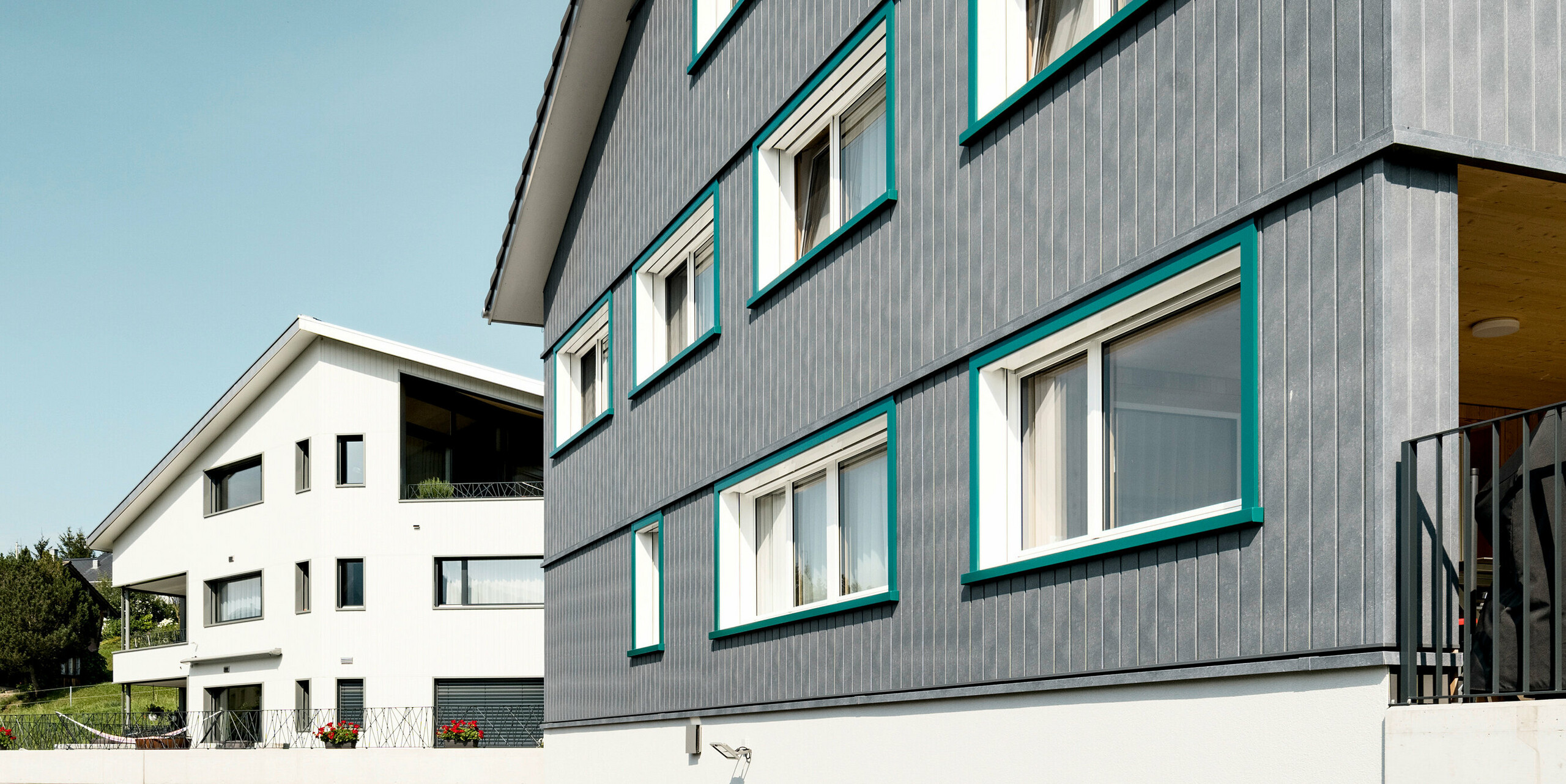 Sidings PREFA en gris pierre P.10 et blanc Prefa P.10 sur les façades de deux immeubles d'habitation voisins à Weissbad, en Suisse.