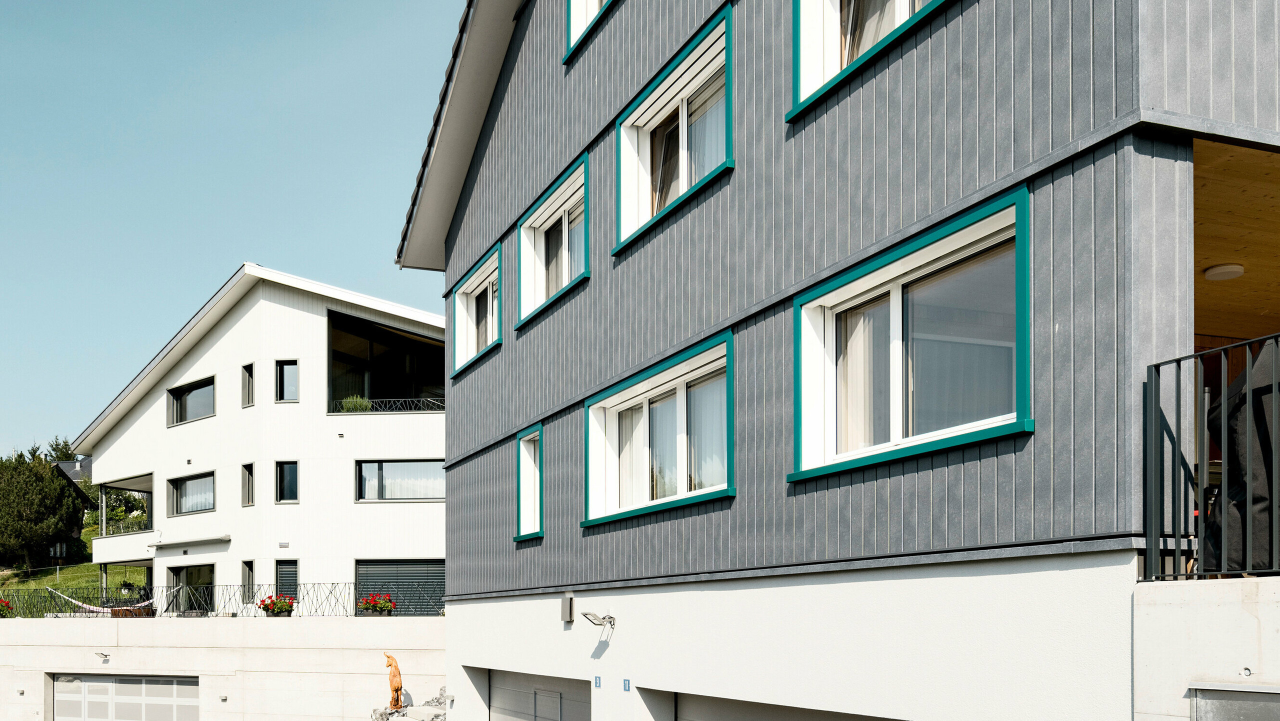 Sidings PREFA en gris pierre P.10 et blanc Prefa P.10 sur les façades de deux immeubles d'habitation voisins à Weissbad, en Suisse.