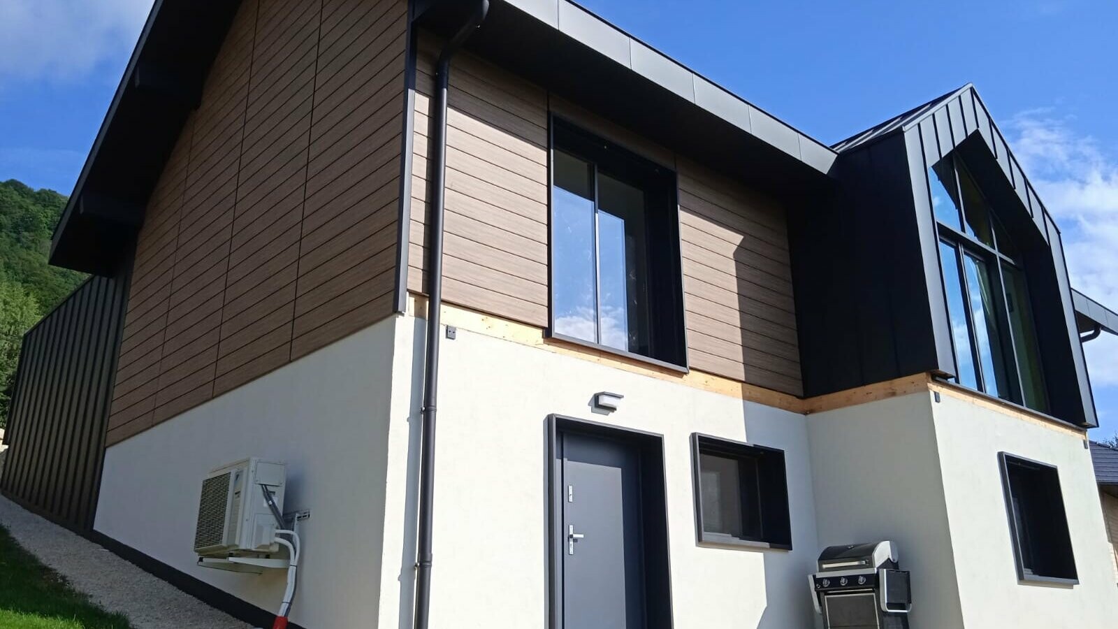 Prise de vue plongeante où cette impressionnante maison individuelle est habillée de Siding et Prefalz dans les teintes noyer foncé et noir P.10