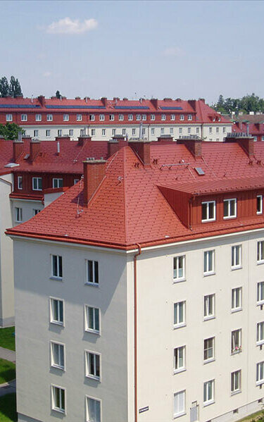 Aménagement des combles de la résidence Hugo-Breitner à Vienne grâce aux bardeaux PREFA dans la teinte rouge tuile