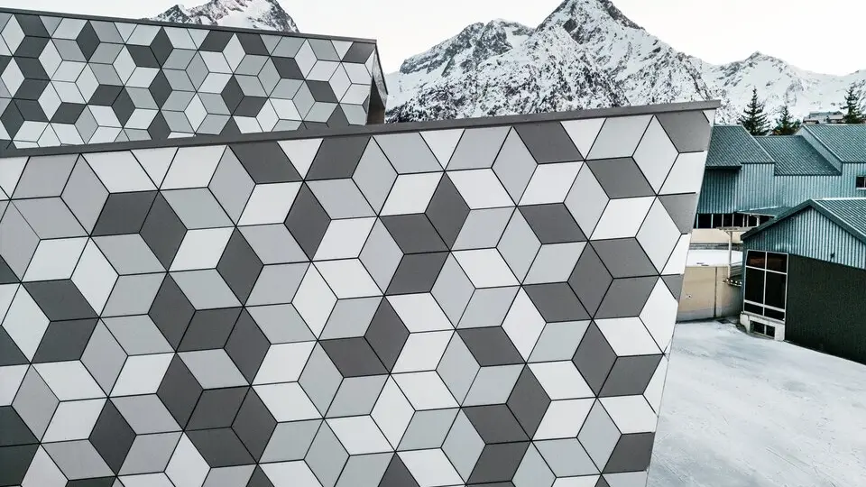 Zoom sur la station du nouveau téléphérique Le Jandri de la station Les 2 Alpes, recouverte de panneaux composites en aluminium PREFABOND façonné en losanges de trois couleurs différentes : blanc Prefa, blanc pur et argent fumé.