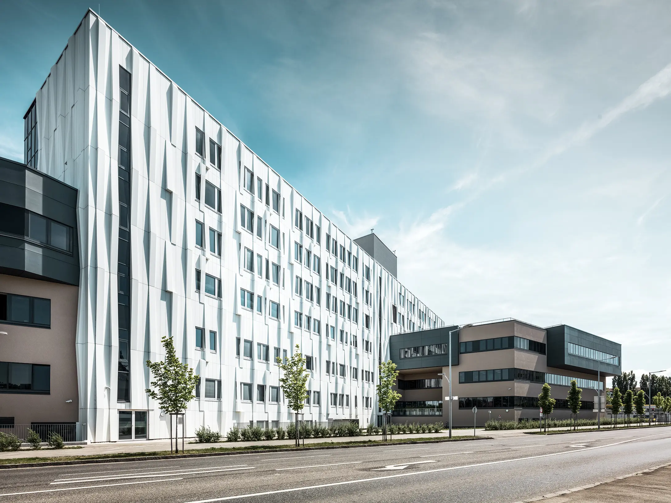 Entrée de la gare routière de Lenti ; la sous-face de la toiture est revêtue de panneaux composites en aluminium PREFABOND de PREFA en blanc pur, tandis que les éléments de façade au niveau des portes d'entrée et des vitrines sont revêtus de P.10 anthracite.