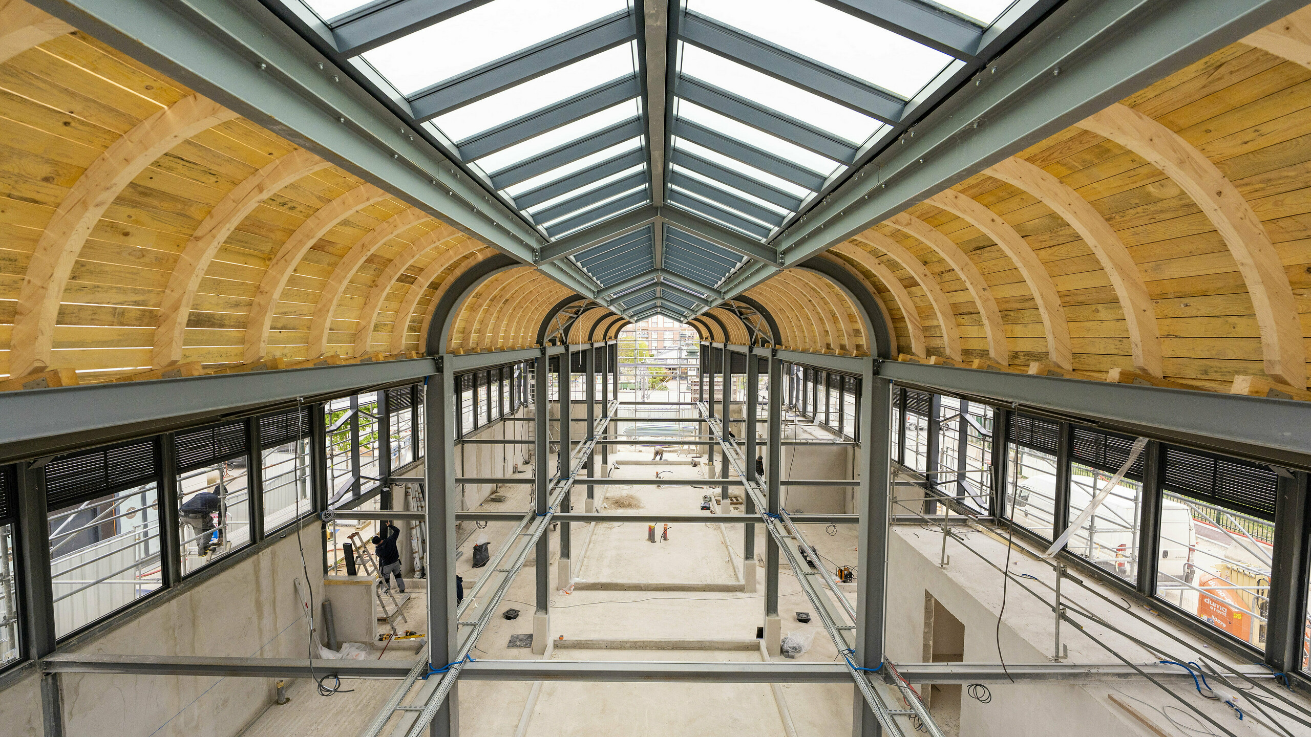Photo de l'intérieure de la Halle de Clamart encore vide, on aperçoit la charpente métallique et en bois.
