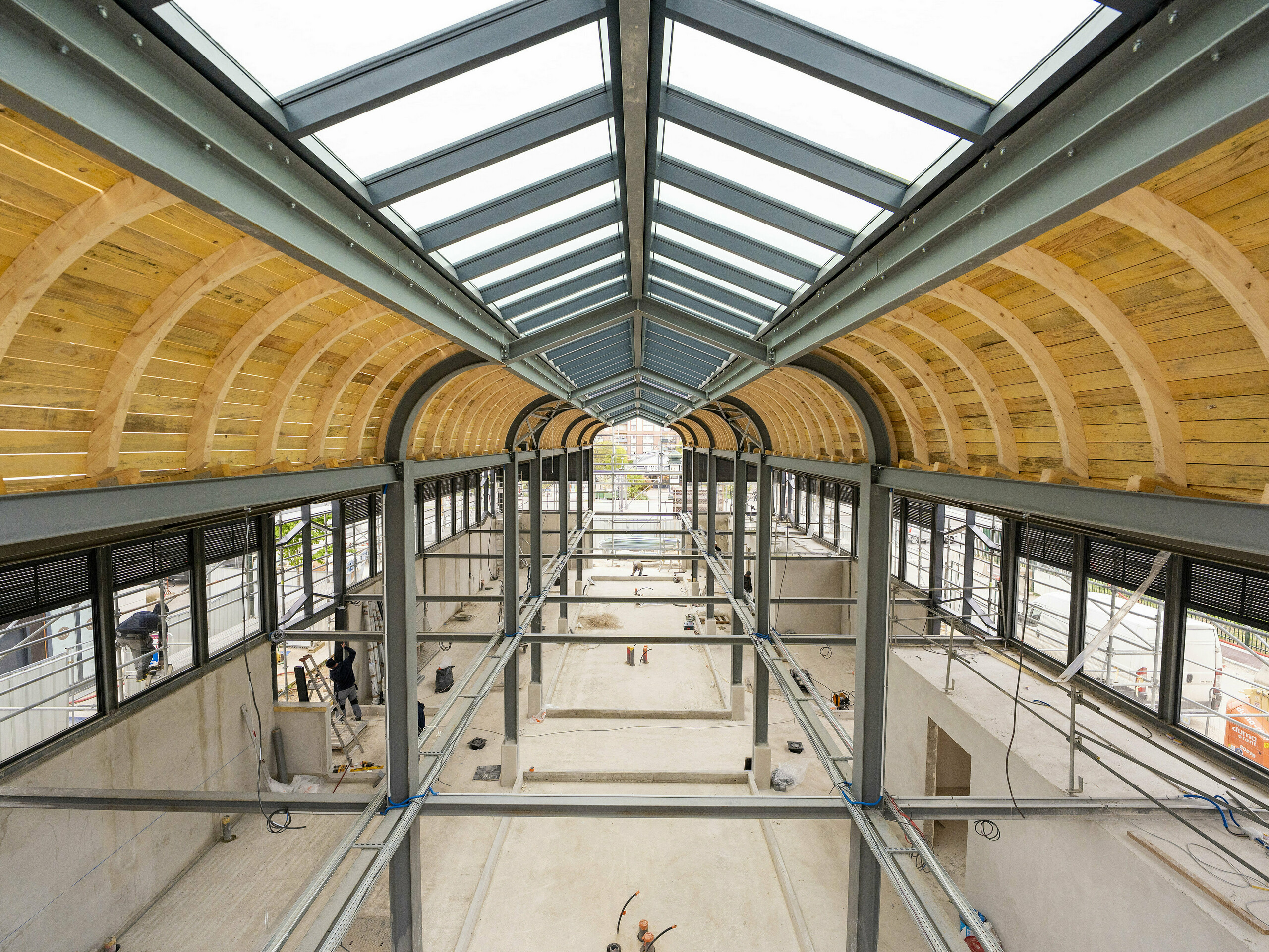 Photo de l'intérieure de la Halle de Clamart encore vide, on aperçoit la charpente métallique et en bois.