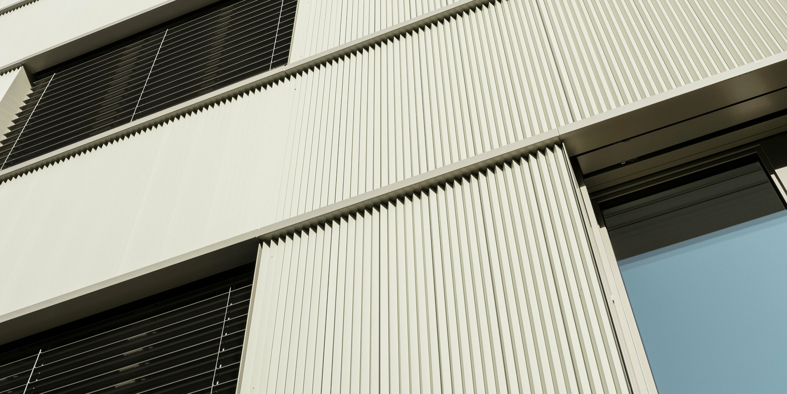 Le bâtiment résidentiel moderne "Stetterhaus" à Altstetten, Zurich, est entouré d'une façade unique - le profil dentelé PREFA dans la couleur métallique perle spéciale.