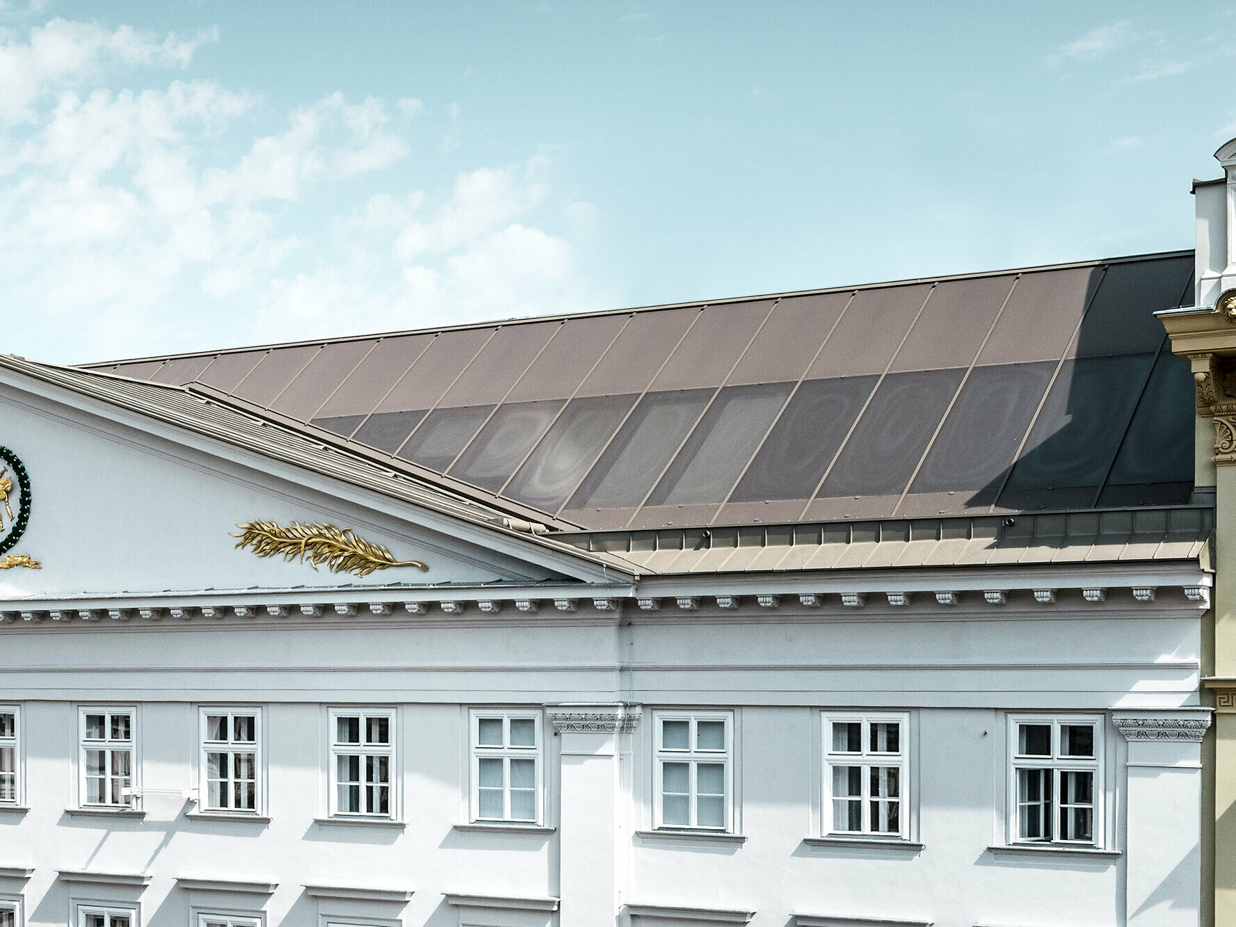 Vue rapprochée d’une partie de la façade et de la toiture Prefalz, avec les vitrages sérigraphiés.
