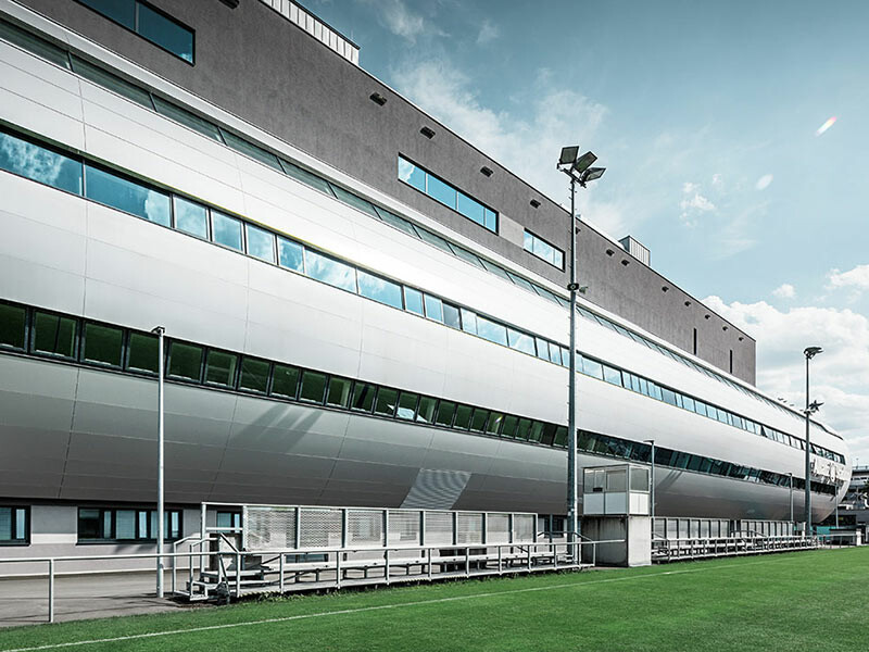 Vue de l’Allianz Stadion à Vienne depuis le terrain d’entraînement ; le tube conduisant à l’intérieur du stade est habillé avec le panneau composite en aluminium PREFA couleur argent métallisé.