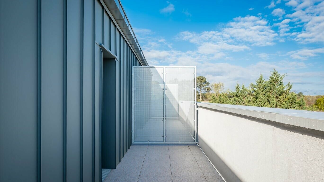 Prise de vue depuis le balcon, on aperçoit la façade en joint debout Prefalz 
