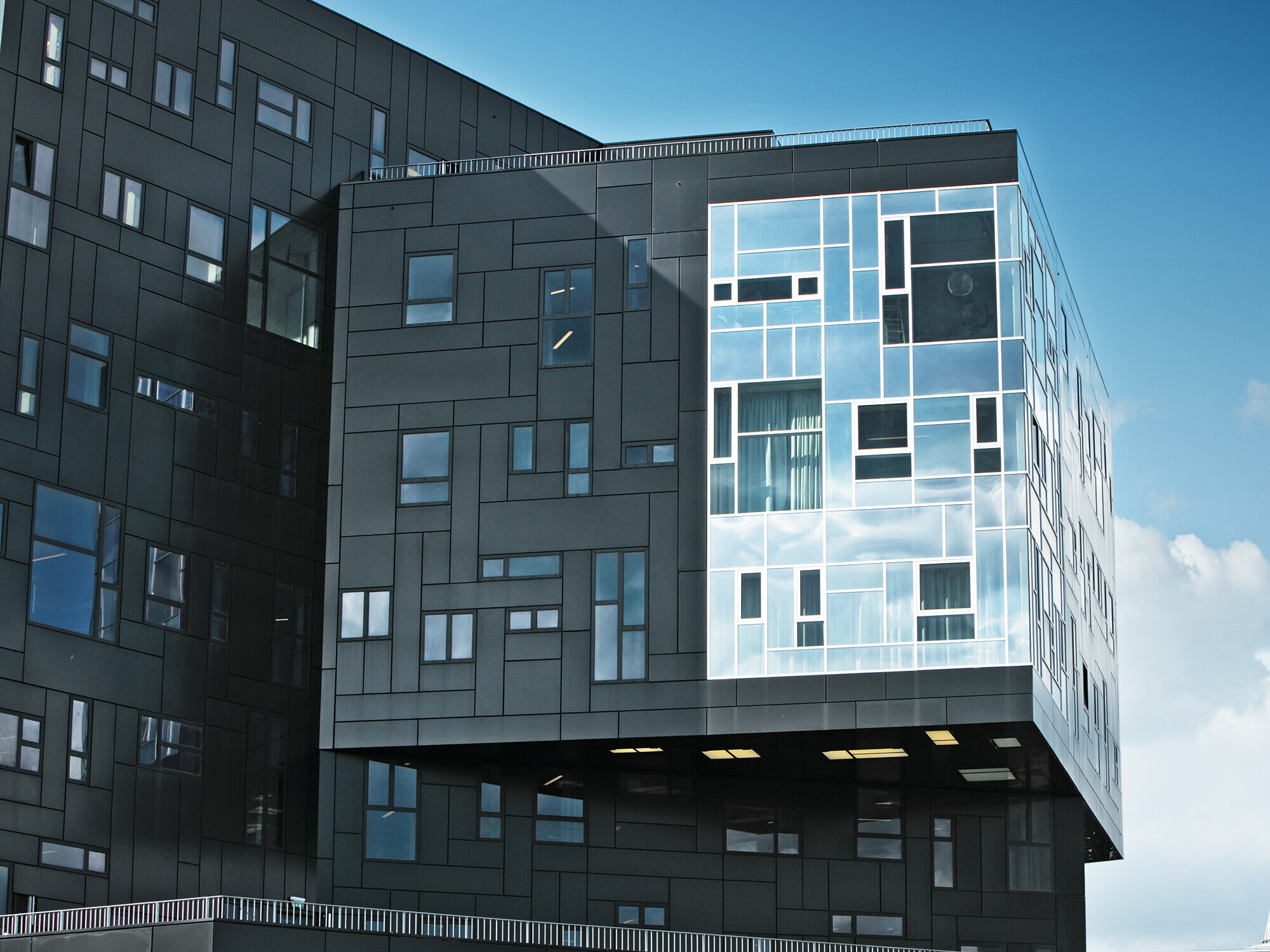 Photo prise par la WU Executive Academy mettant en avant la façade en panneaux composites aluminium PREFA noir intense et la partie vitrée brillante.