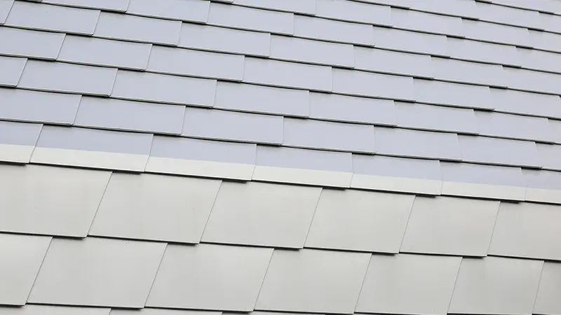 Point de détails, zoom sur le raccord entre toiture et façade avec les bardeaux PREFA dans la teinte argent métallisé