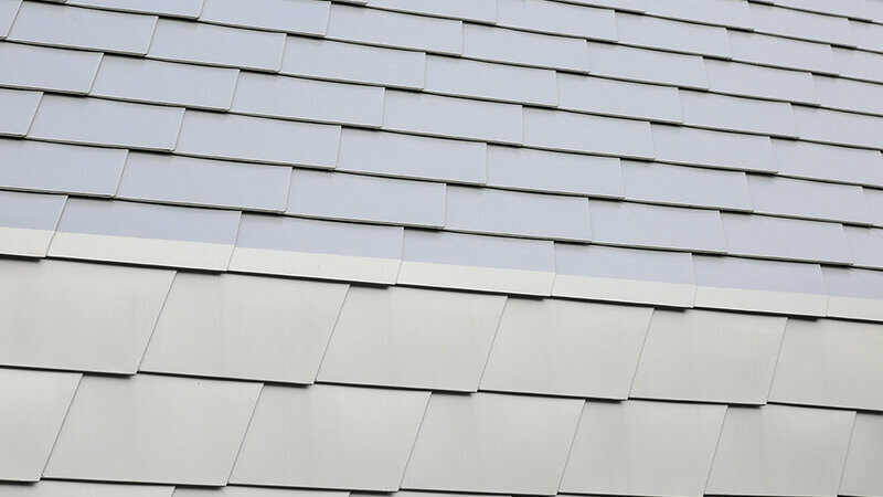 Point de détails, zoom sur le raccord entre toiture et façade avec les bardeaux PREFA dans la teinte argent métallisé