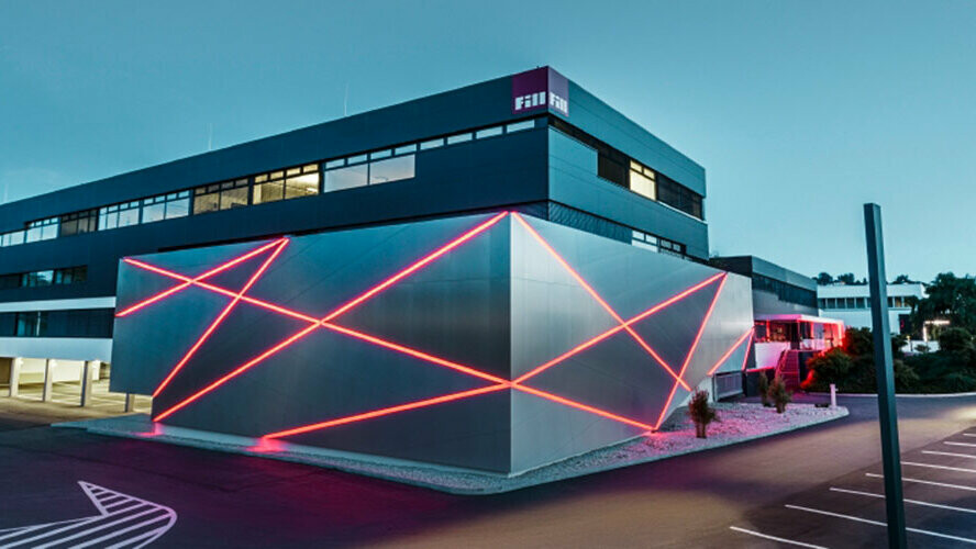 Façade d’un bâtiment de société avec une ligne de bris dans le mur, revêtue de panneaux composites PREFA en aluminium brossé.