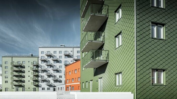 Modernes Wohnhaus-Ensemble in Schweden, eingedeckt mit PREFA Wandrauten 29 × 29 in dunklen Erdfarben
