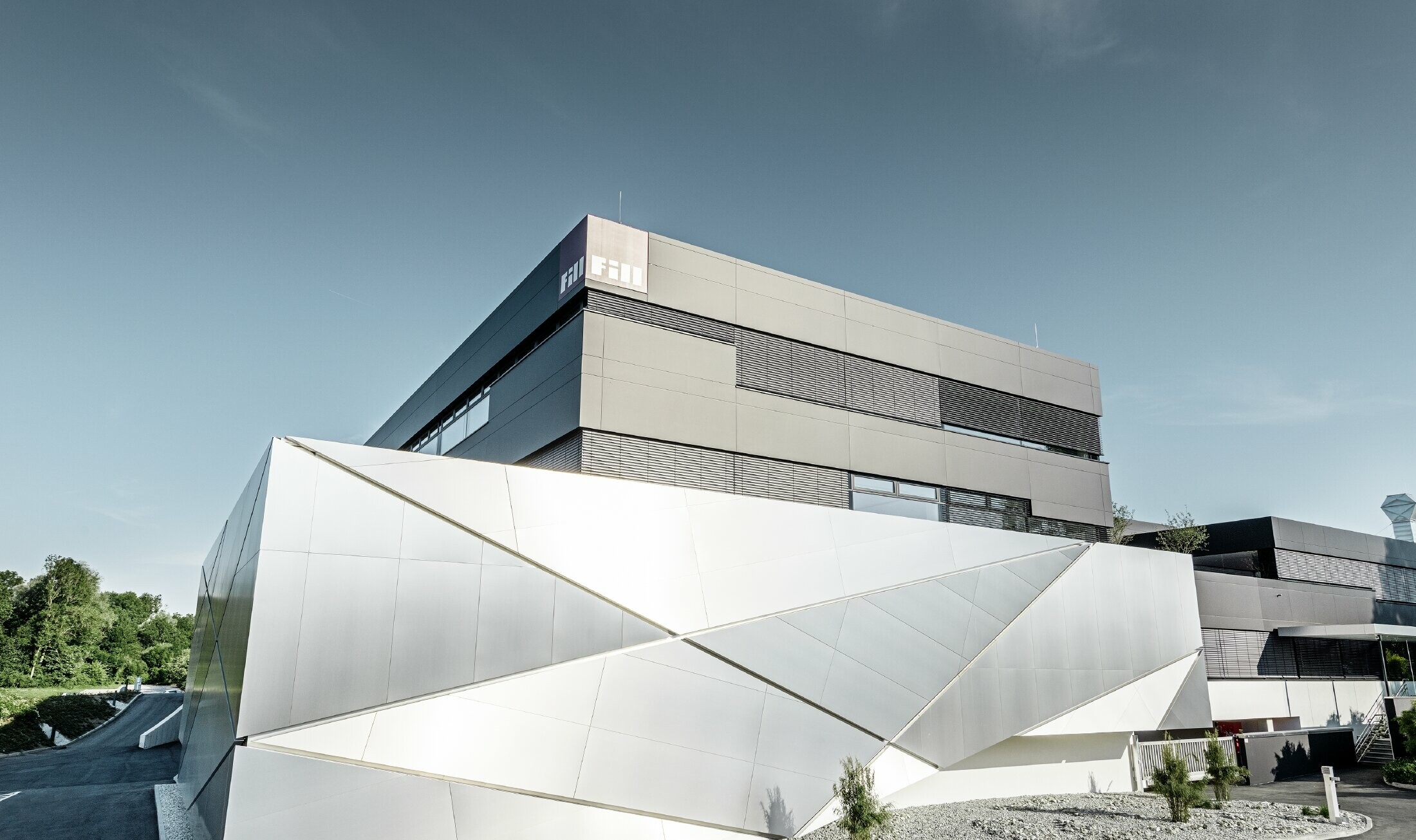 Bâtiment d’entreprise de la société Fill — Façade futuriste aux joints rétroéclairés réalisée avec des panneaux composites PREFA en aluminium brossé