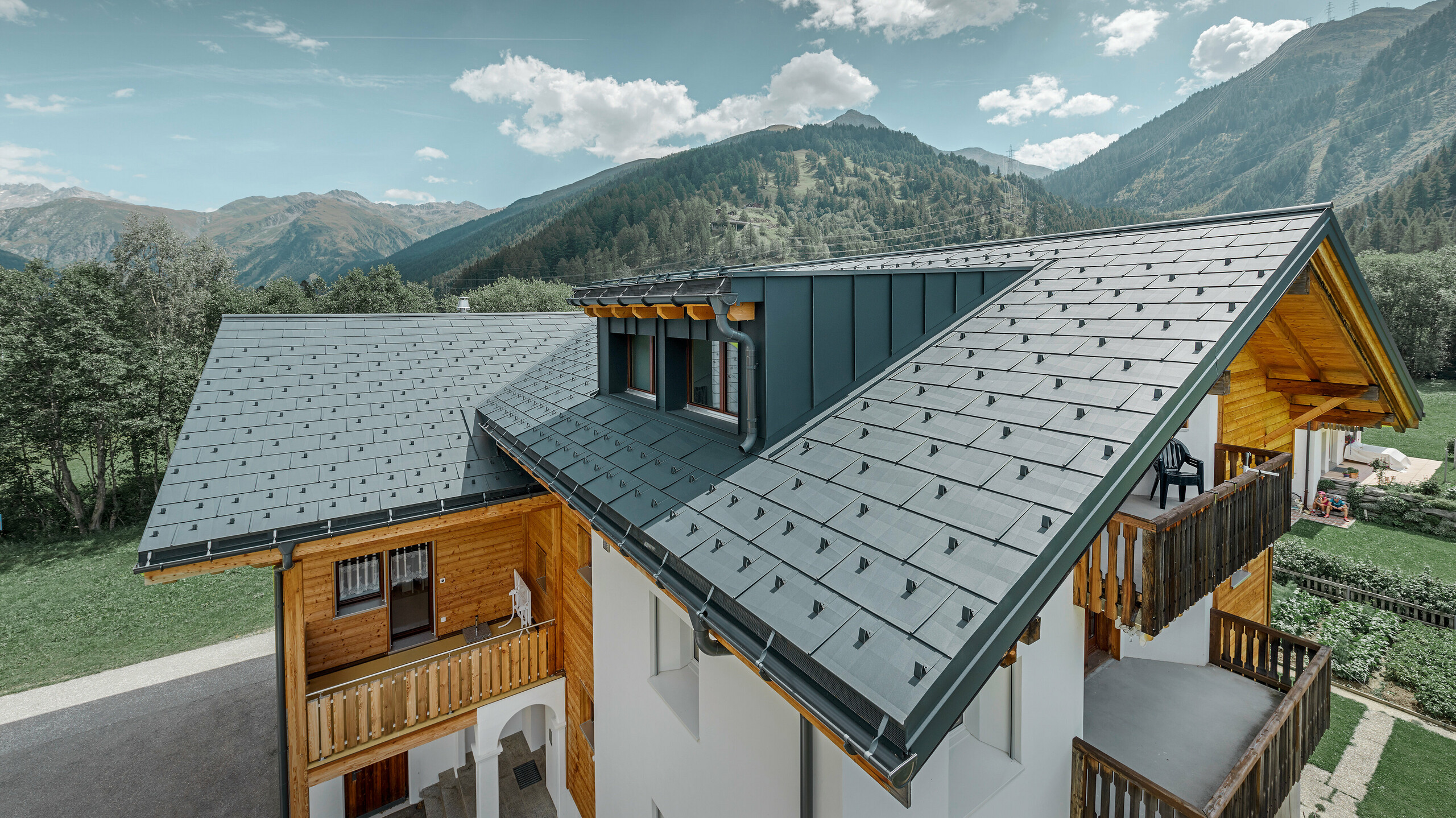 PREFA Obergoms Zuber système de toit panneau de toiture FX12 anthracite Montanara Bâtiment d’habitation rénové avec toit à deux pans et lucarne ; la rénovation de la toiture a été réalisée avec le panneau de toiture FX.12 PREFA couleur anthracite.