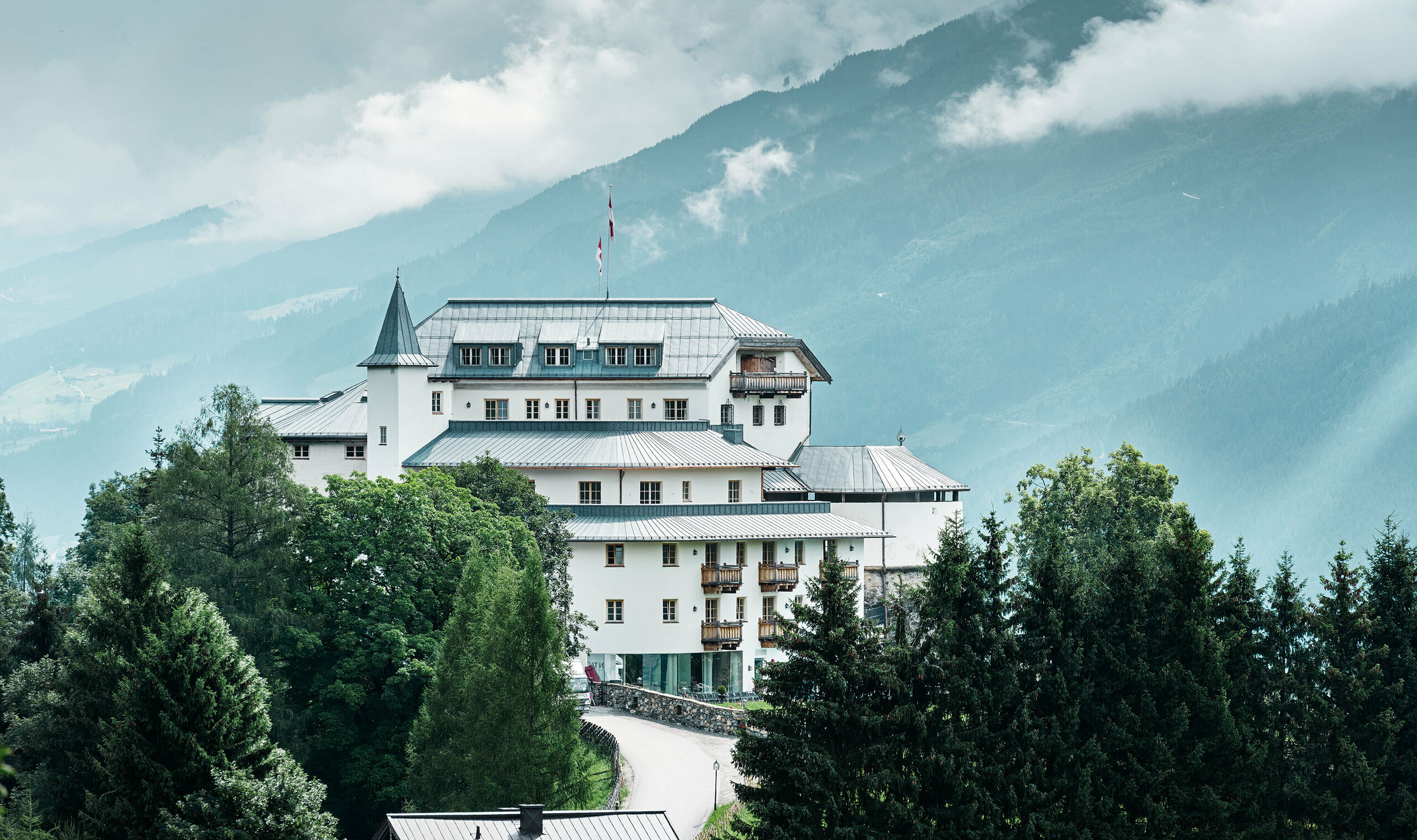 Château de Mittersill entouré d’arbres et de montagnes — Toiture rénovée avec des bandes Prefalz de couleur gris pierre