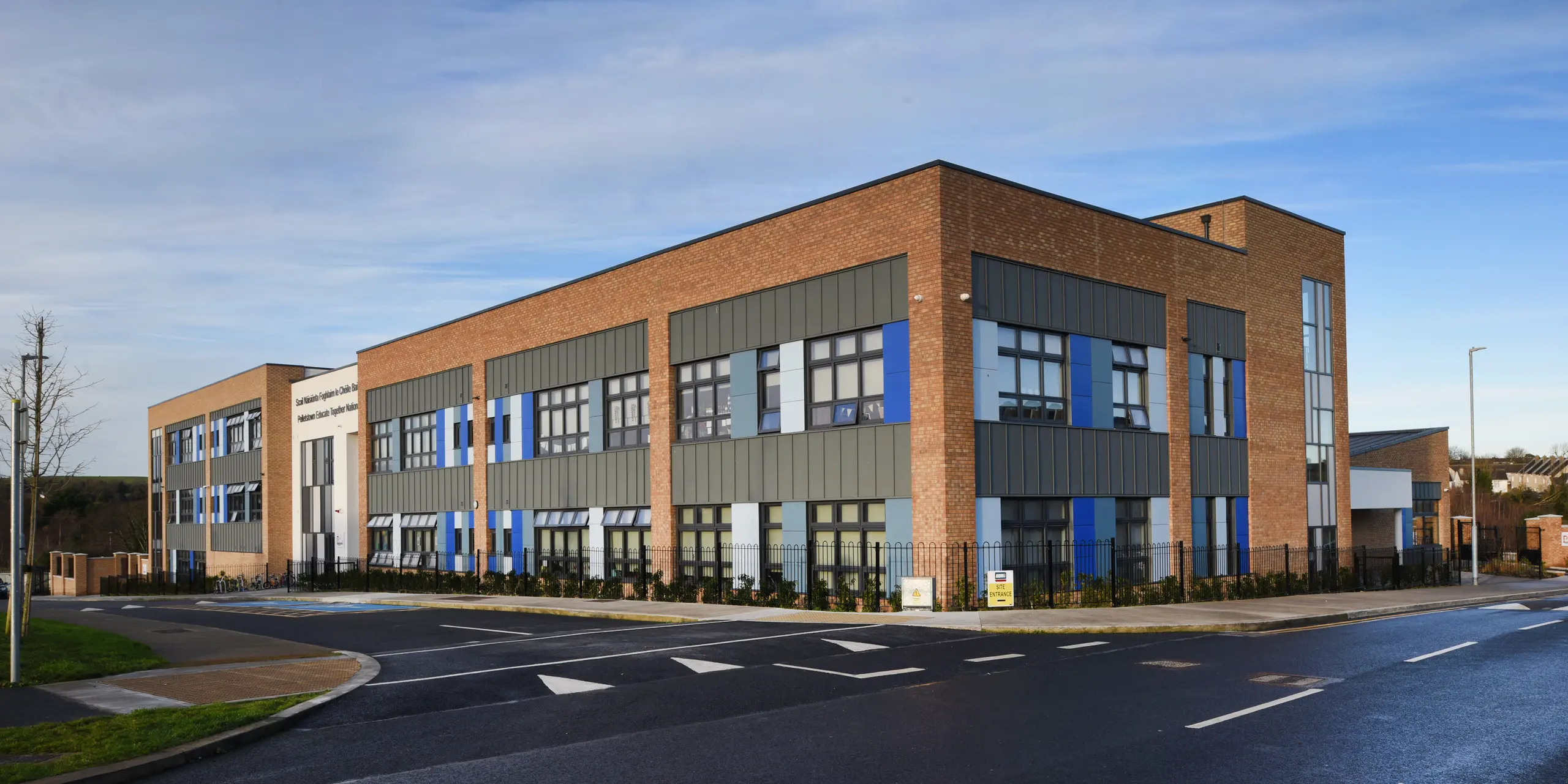 Vue latérale de l'école nationale Pelletstown Educate Together à Dublin. La toiture à joint debout PREFALZ gris souris forme une peau extérieure élégante et résistante aux intempéries. Les éléments en aluminium assurent une transition harmonieuse avec les façades en clinker et en crépi - un mélange unique de matériaux.