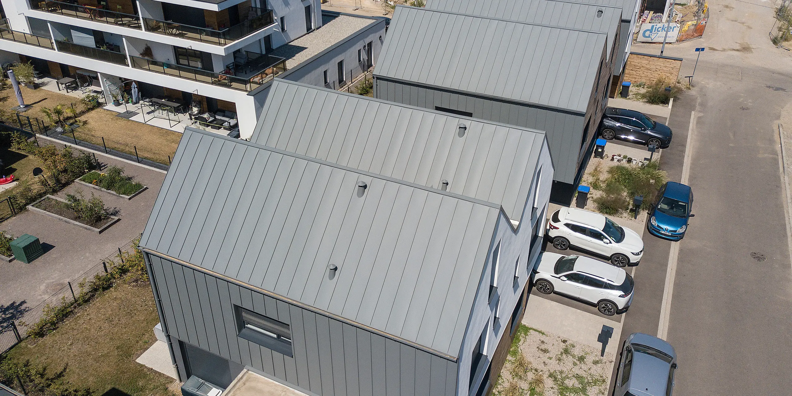 Le joint debout PREFALZ en gris souris s'étend sur les façades et les toits à pignon d'un lotissement mitoyen à Mundolsheim. Les coques uniformes du bâtiment en aluminium créent une image globale harmonieuse.