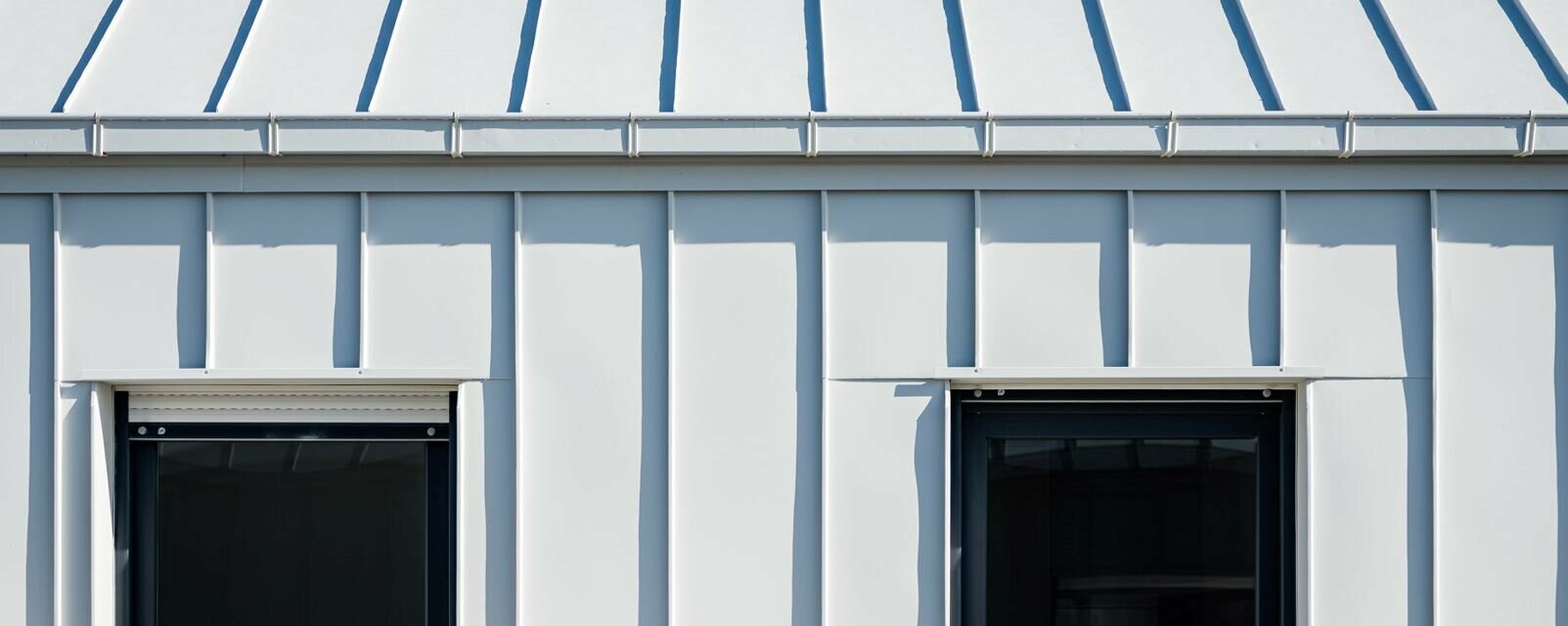 Zoom sur la toiture, façade et gouttière en aluminium PREFA dans la teinte P.10 blanc pur