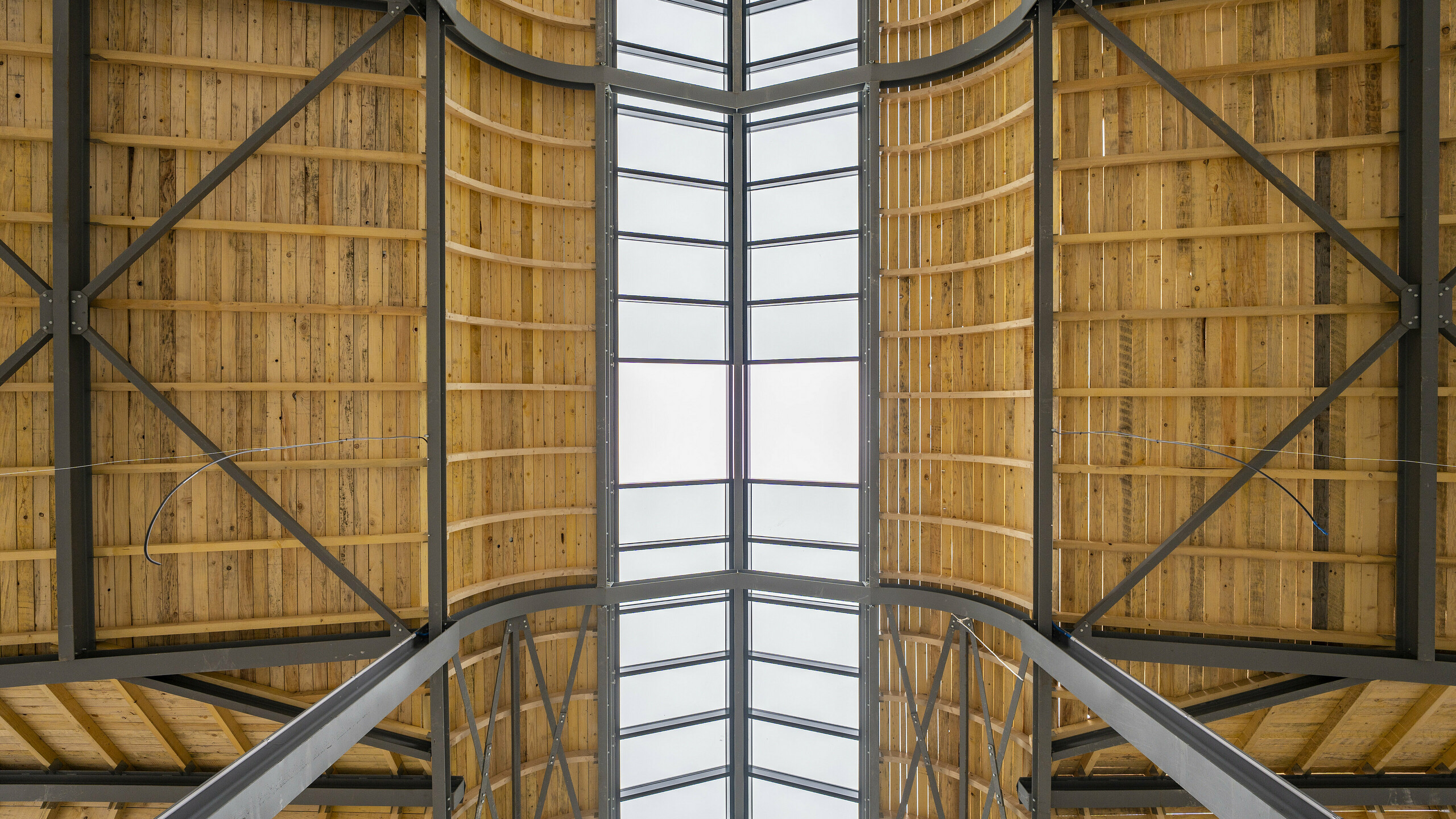 Photo de l'intérieure de la Halle de Clamart encore vide, on aperçoit la charpente métallique et en bois.