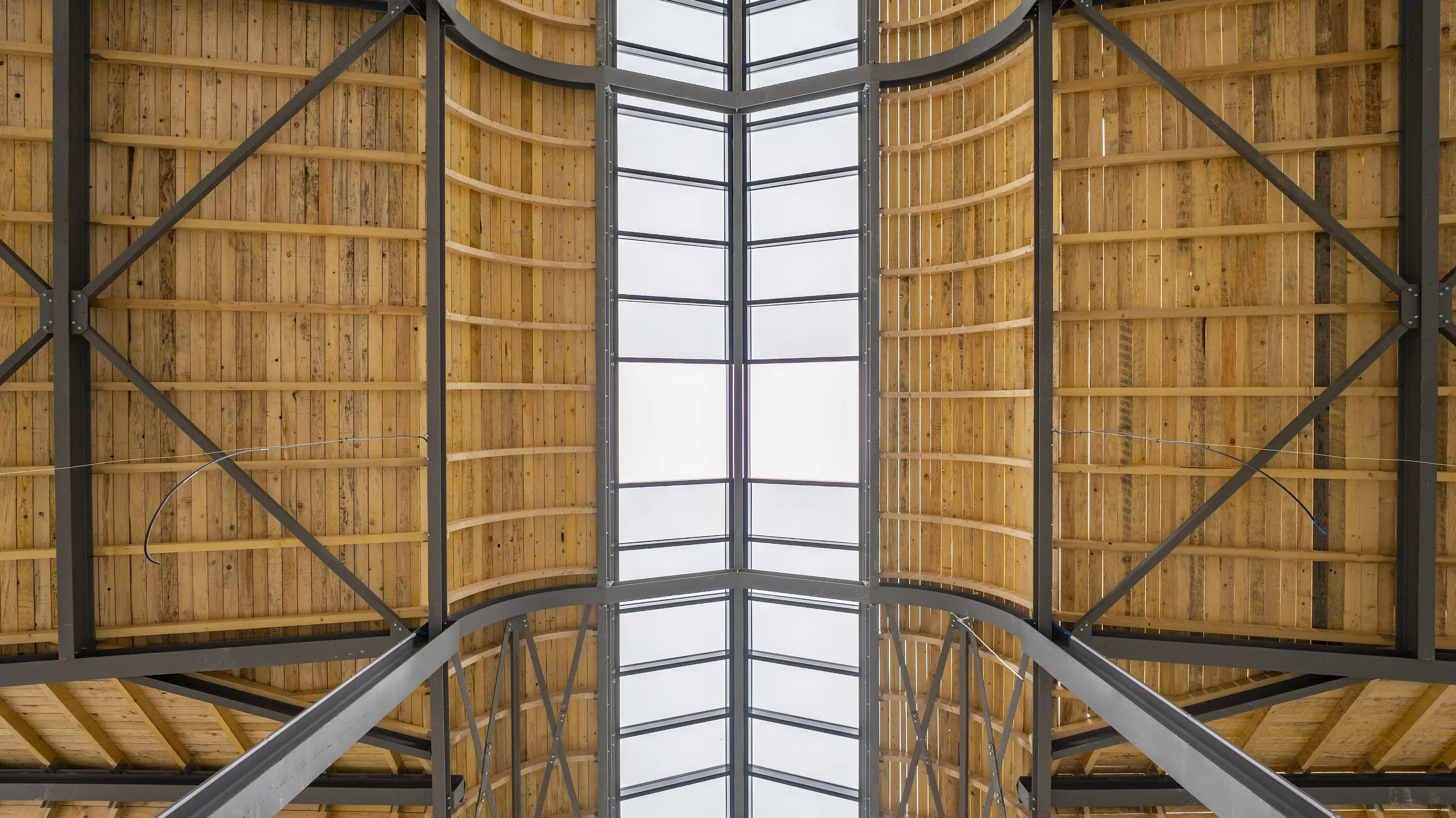 Photo de l'intérieure de la Halle de Clamart encore vide, on aperçoit la charpente métallique et en bois.