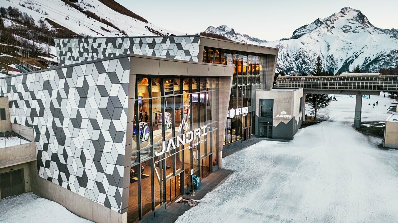 Prise de la première station du nouveau téléphérique Le Jandri de la station Les 2 Alpes, recouverte de panneaux composites en aluminium PREFABOND façonné en losanges de trois couleurs différentes : blanc Prefa, blanc pur et argent fumé.