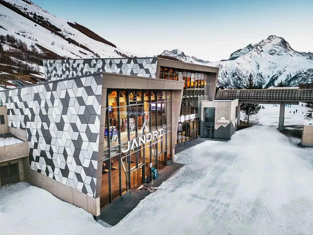 Prise de la première station du nouveau téléphérique Le Jandri de la station Les 2 Alpes, recouverte de panneaux composites en aluminium PREFABOND façonné en losanges de trois couleurs différentes : blanc Prefa, blanc pur et argent fumé.