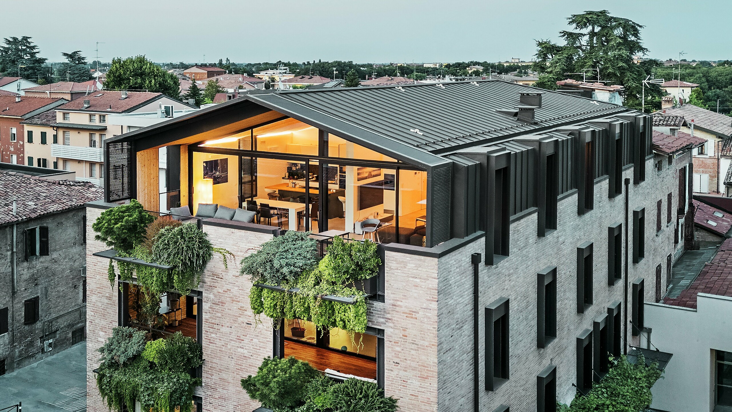 Maison durable en Italie avec toiture en aluminium PREFALZ et façade en briques végétalisée.