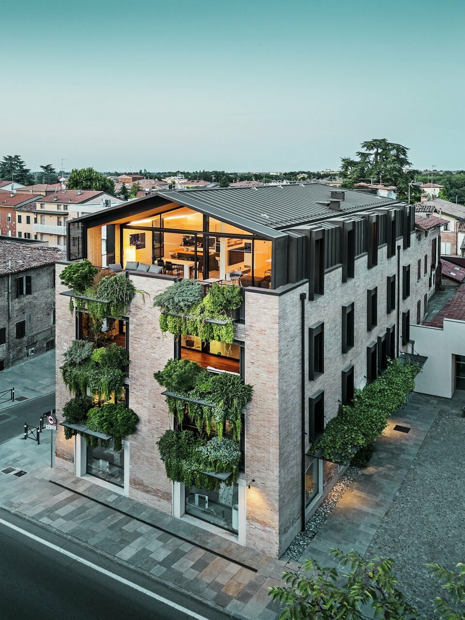 Maison durable en Italie avec toiture en aluminium PREFALZ et façade en briques végétalisée.