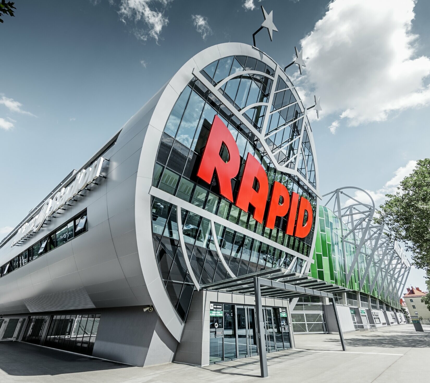 L’entrée de l’Allianz Stadion avec le grand logo du SK Rapid de Vienne ; le tube avec la grande façade vitrée est recouvert du panneau composite en aluminium PREFA couleur argent métallisé.
