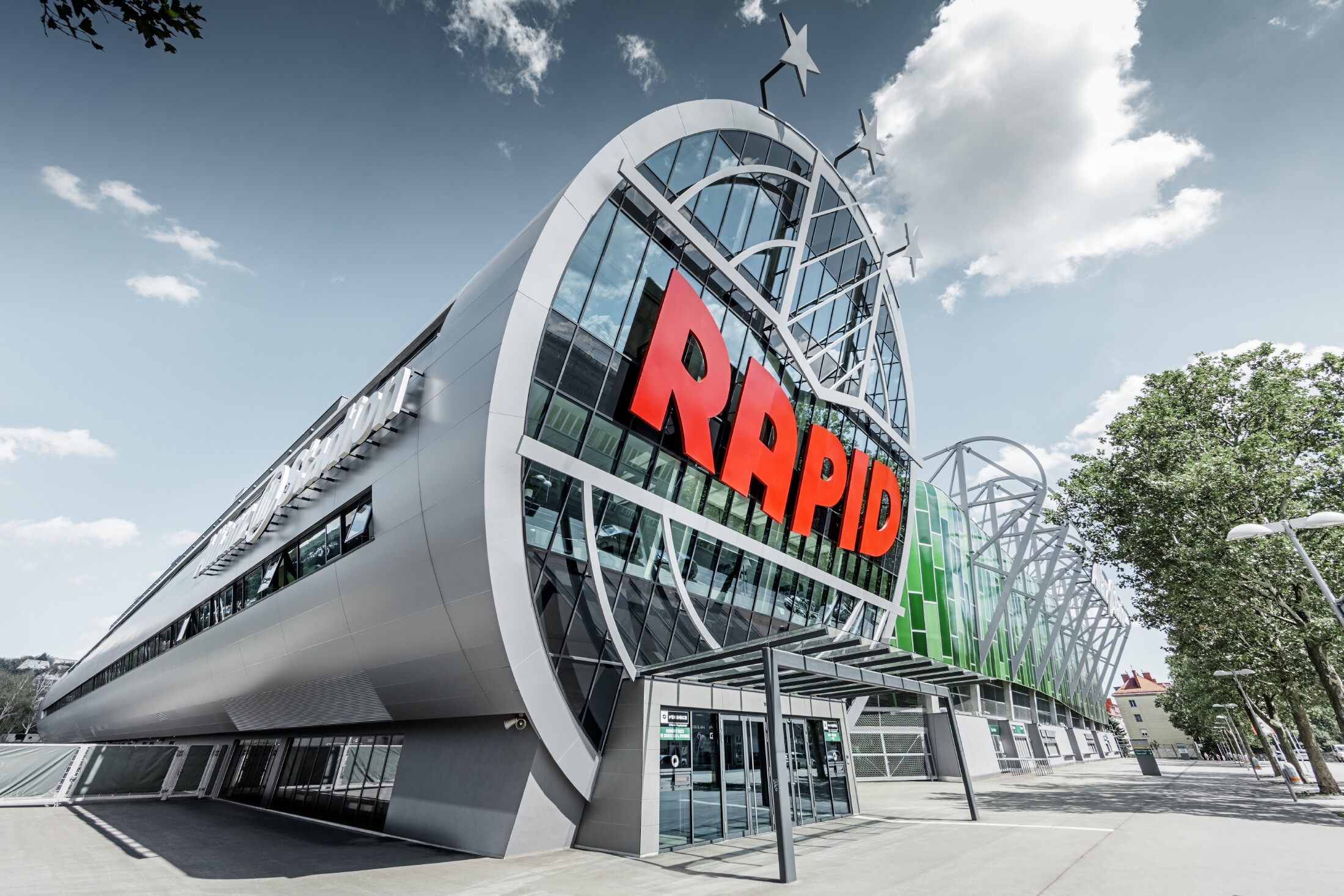 L’entrée de l’Allianz Stadion avec le grand logo du SK Rapid de Vienne ; le tube avec la grande façade vitrée est recouvert du panneau composite en aluminium PREFA couleur argent métallisé.