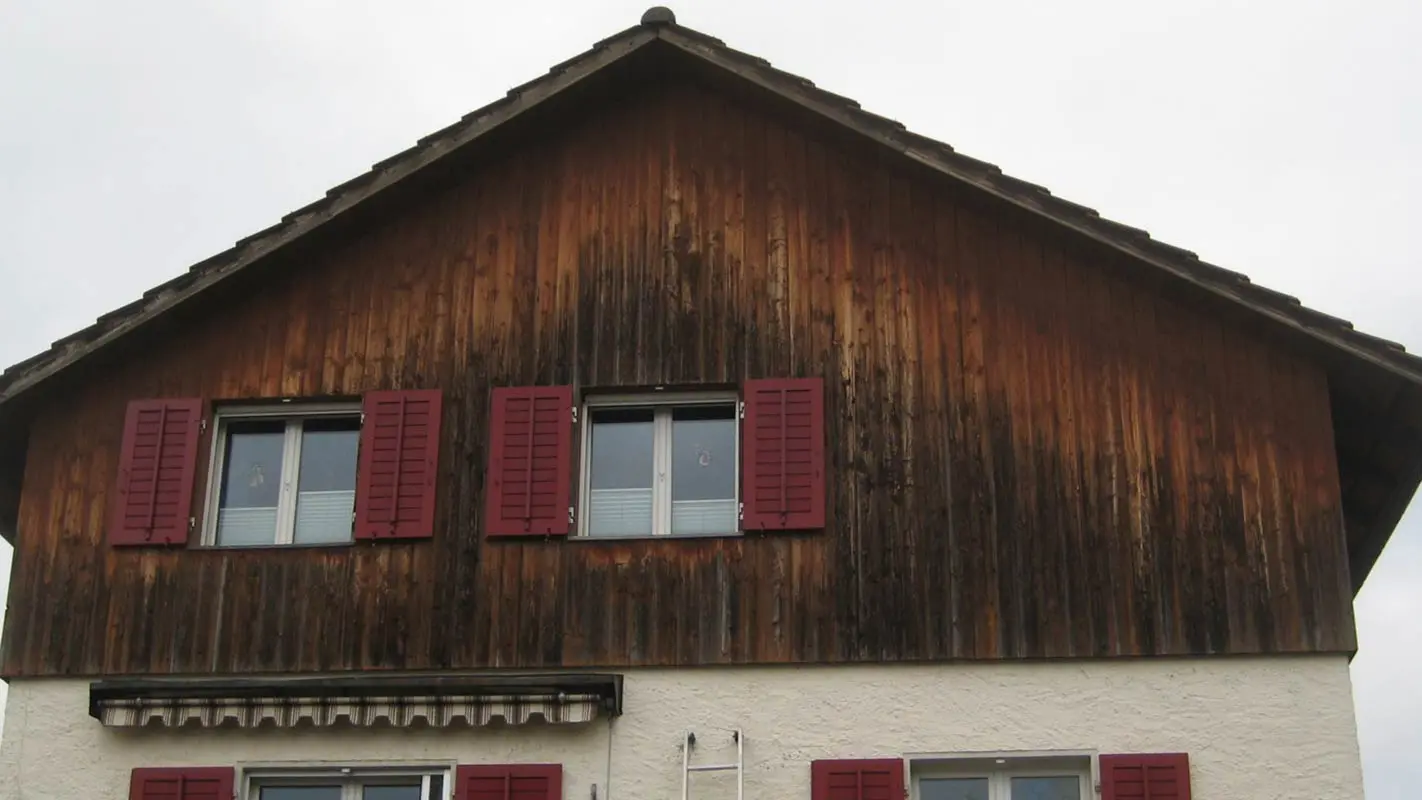 Façade avec habillage bois abîmé par le temps, avant la rénovation à l’aide de Sidings PREFA