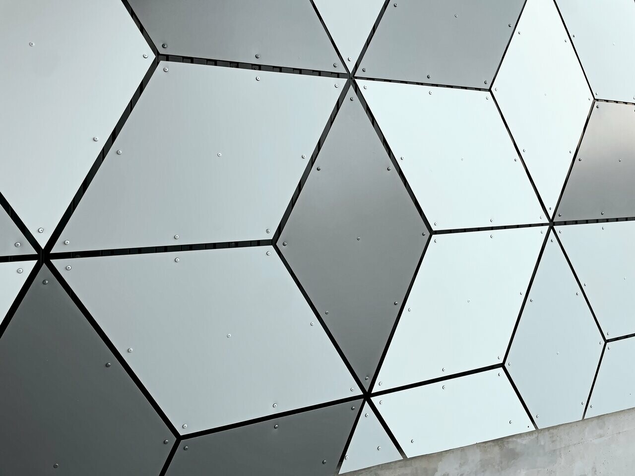 Focus sur les motifs losangés formés par les panneaux composites en aluminium PREFABOND choisis en trois couleurs différentes : blanc Prefa, blanc pur et argent fumé. Le tout sur les façades des stations du nouveau téléphérique Le Jandri implanté à Les 2 Alpes.