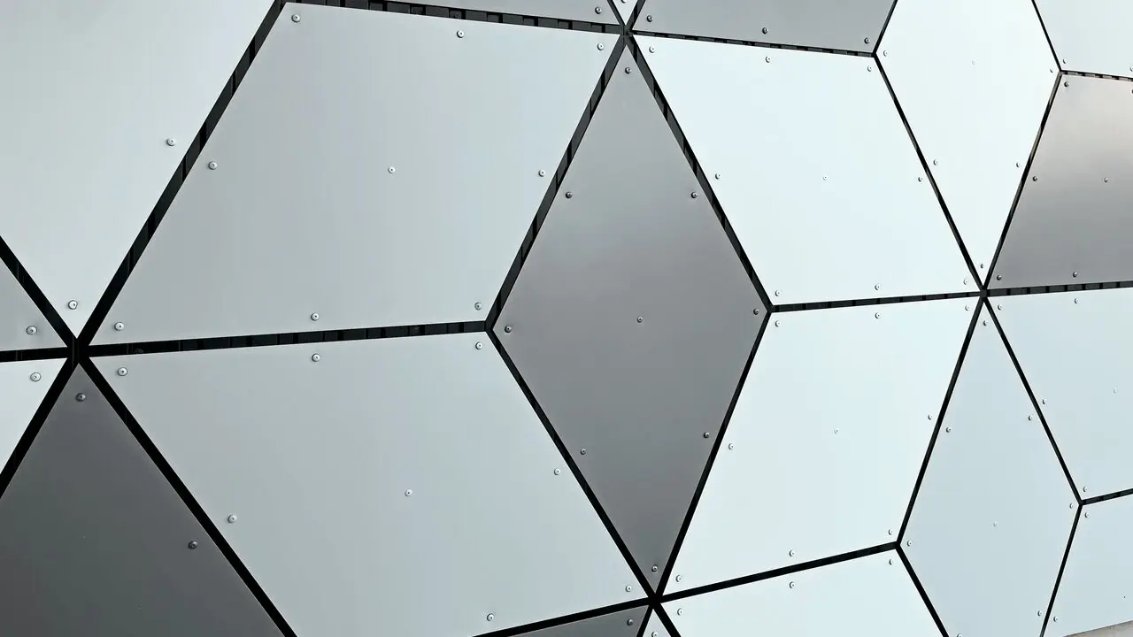 Focus sur les motifs losangés formés par les panneaux composites en aluminium PREFABOND choisis en trois couleurs différentes : blanc Prefa, blanc pur et argent fumé. Le tout sur les façades des stations du nouveau téléphérique Le Jandri implanté à Les 2 Alpes.