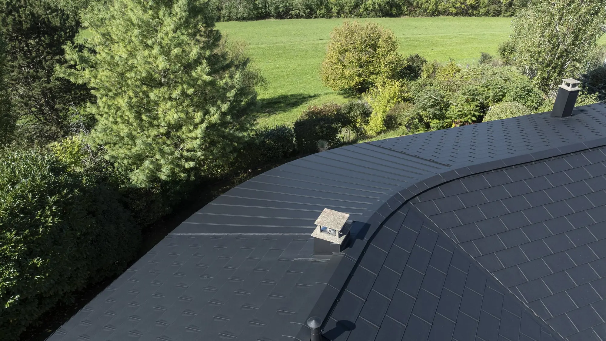 Photo du haut du toit où on distingue clairement le côté courbé et arrondi de la toiture. Un défi technique relevé grâce aux produits PREFA et à la flexibilité de l'aluminium.