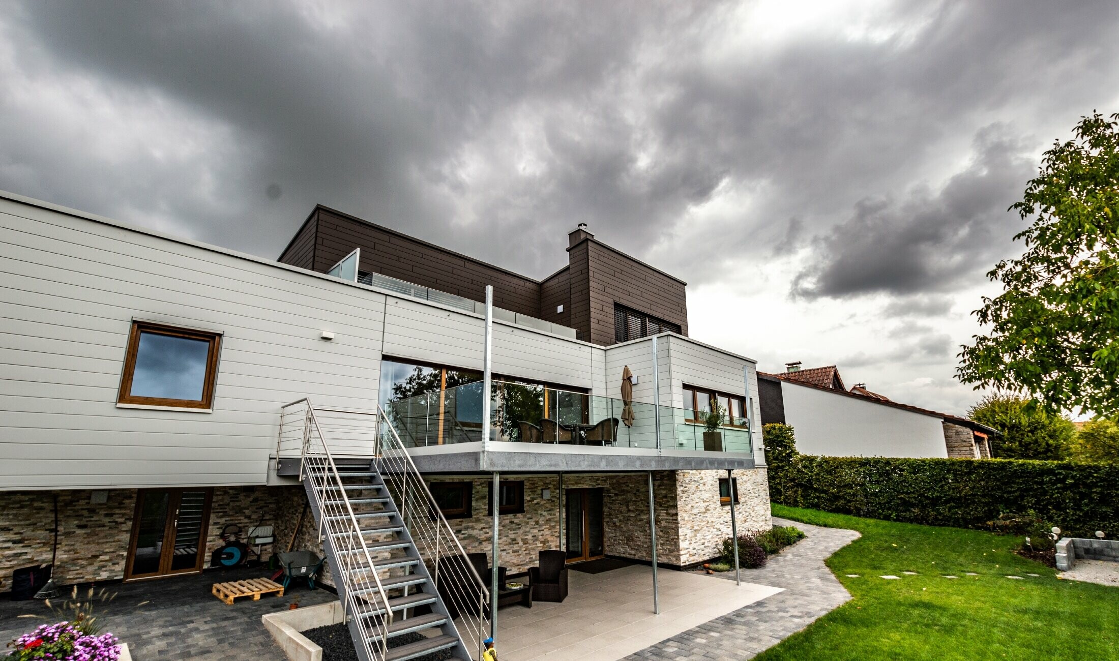 Bâtiment d’habitation à toit plat et façade blanc et brun avec Sidings PREFA posés à l’horizontale.