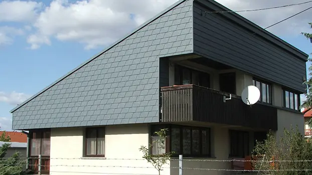 Toiture à un pan avec habillage de la façade à l’étage supérieur. La façade a été recouverte de bardeaux de façade PREFA.
