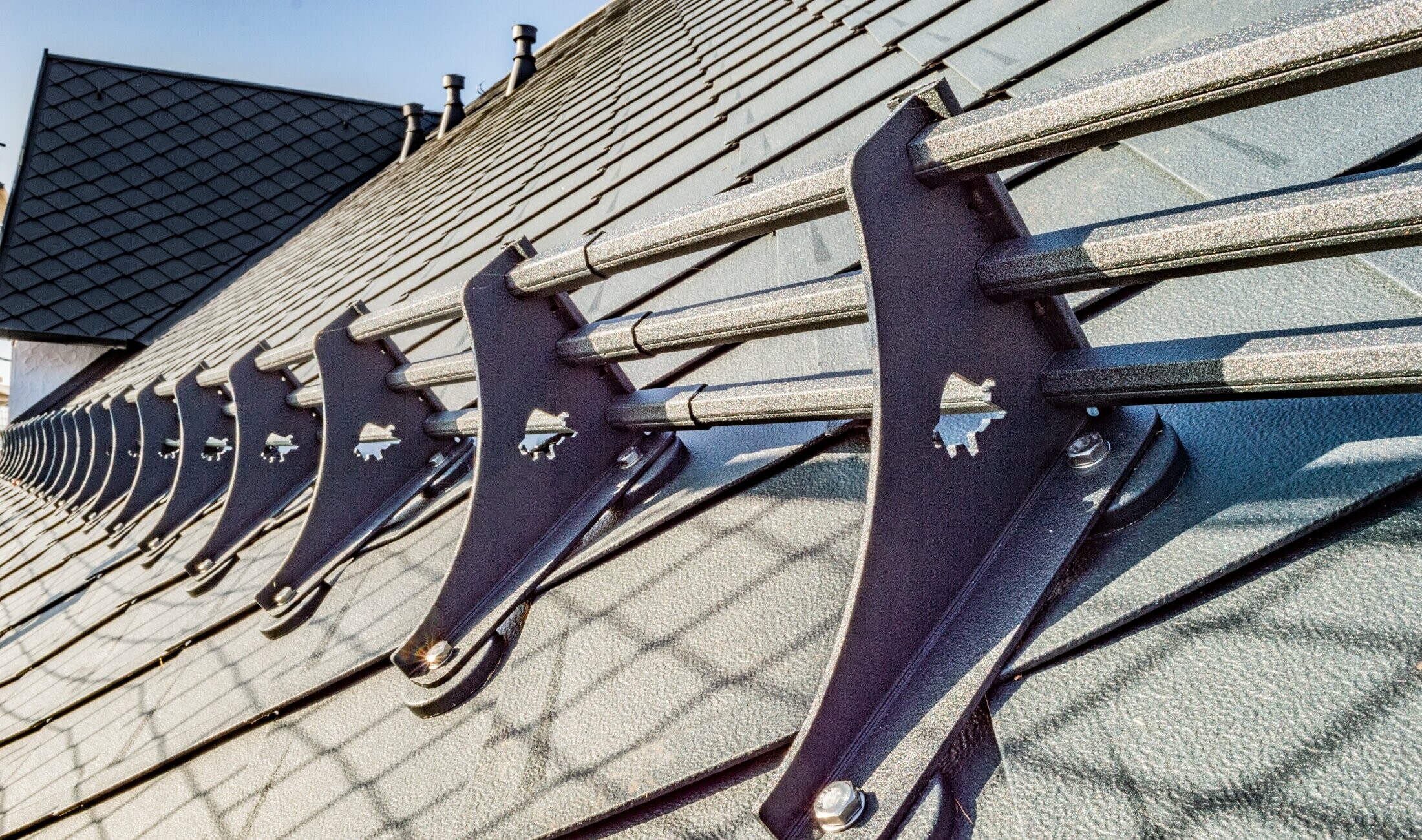 Vue détaillée du système pare-neige PREFA sur le losange de toiture 29 × 29 PREFA couleur anthracite sur l’hôtel Burg Maienluft.