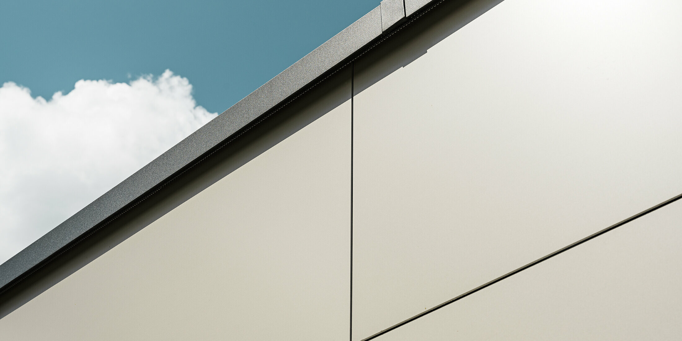 Nahaufnahme einer Garagenverkleidung mit PREFA Aluminium Verbundplatten in edlem Bronze. Die Perspektive zeigt die hohe Verarbeitungsqualität.