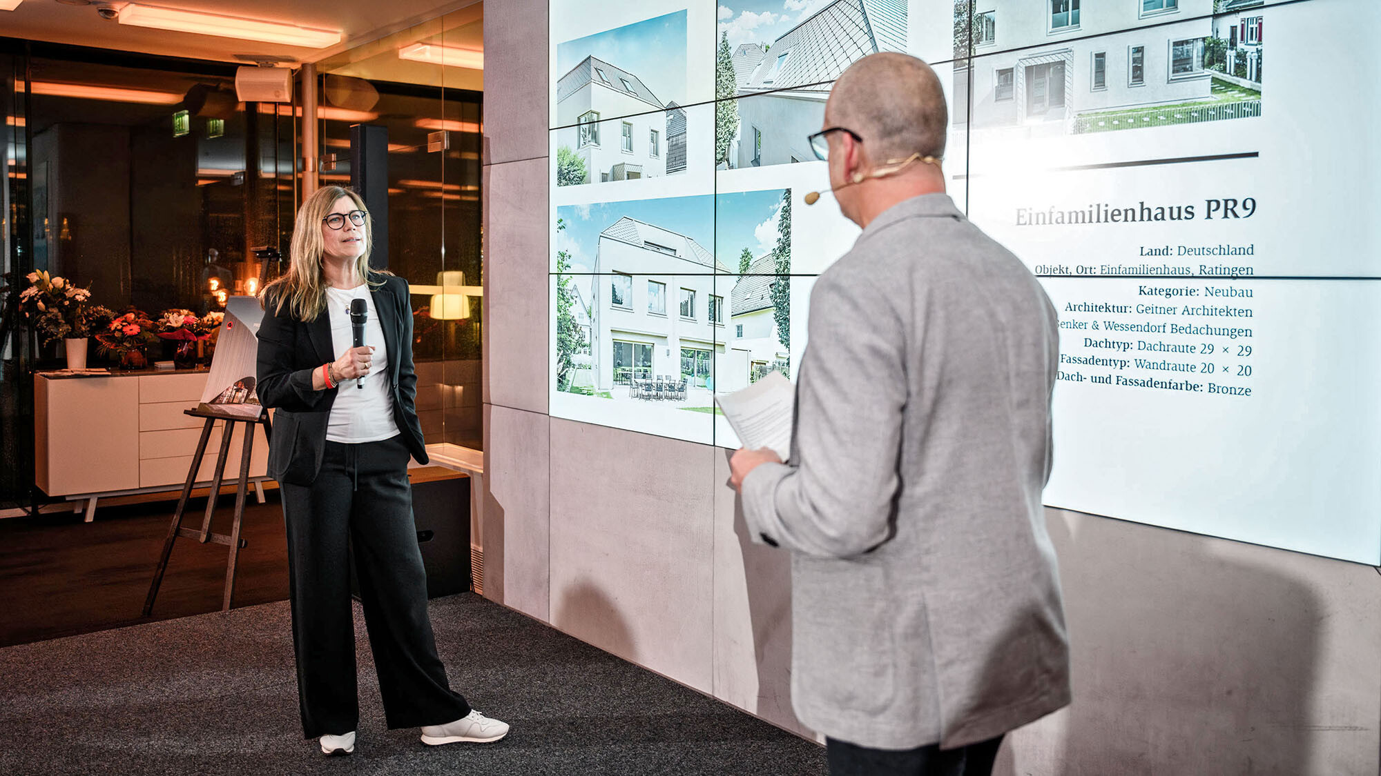 L'architecte Leona Geitner du cabinet allemand Geitner Architekten et le directeur marketing international Jürgen Jungmair conversant devant l'espace de présentation.