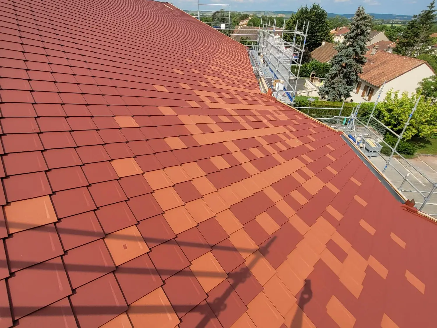 Prise de vue de la toiture rénovée avec les losanges 29x29 PREFA dans les teintes P.10 rouge tuile et rouge oxyde