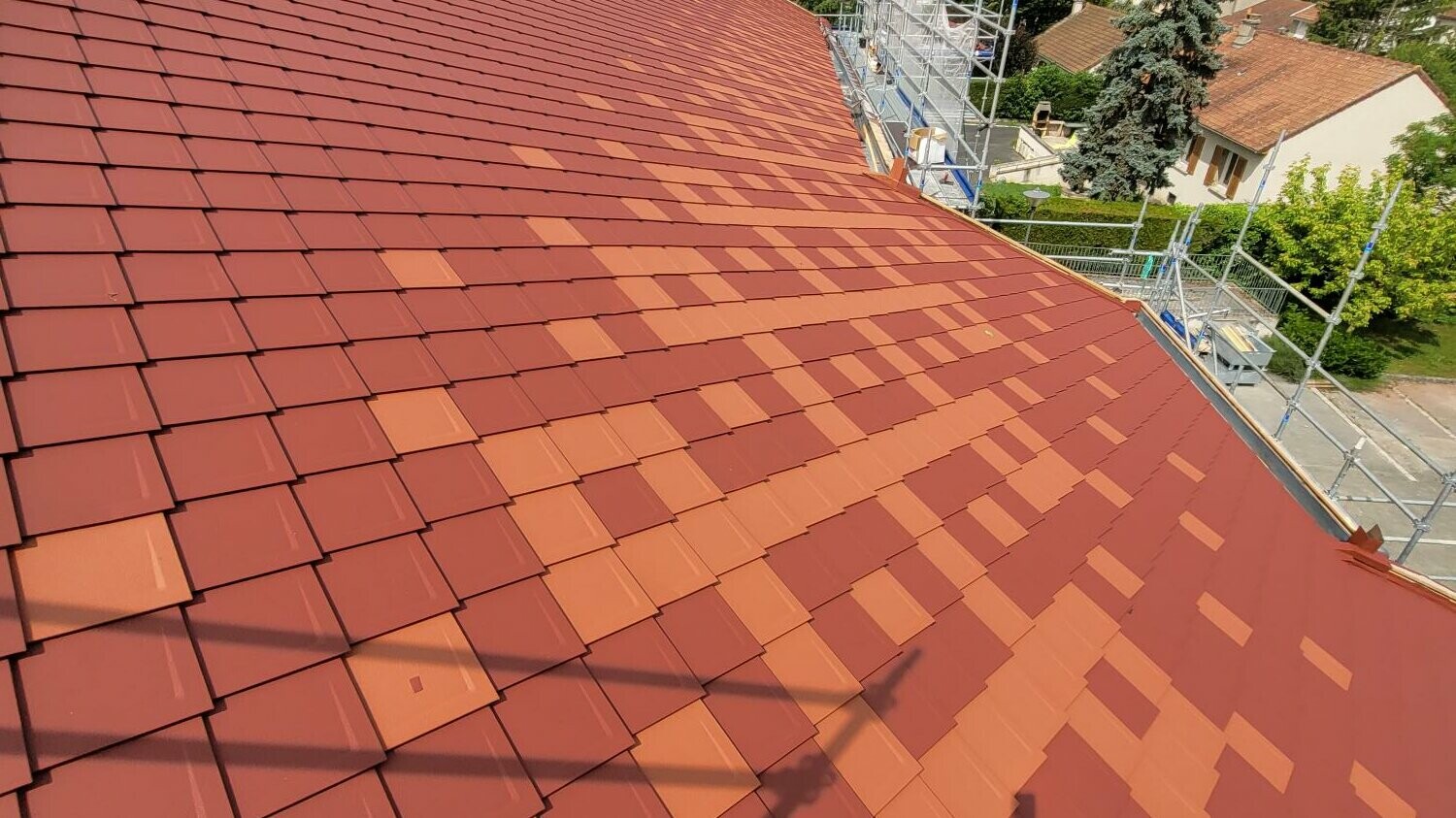 Prise de vue de la toiture rénovée avec les losanges 29x29 PREFA dans les teintes P.10 rouge tuile et rouge oxyde