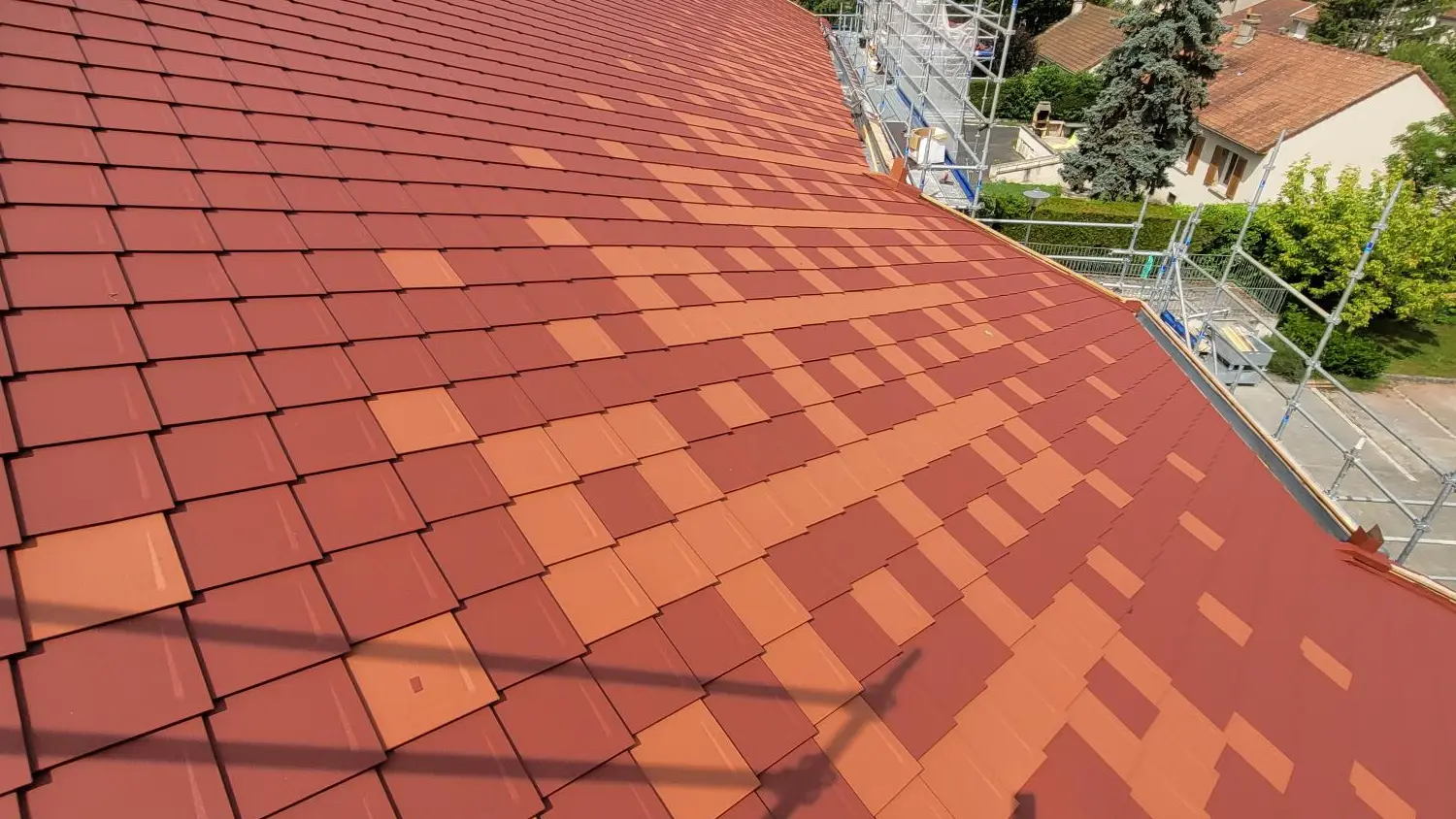 Prise de vue de la toiture rénovée avec les losanges 29x29 PREFA dans les teintes P.10 rouge tuile et rouge oxyde