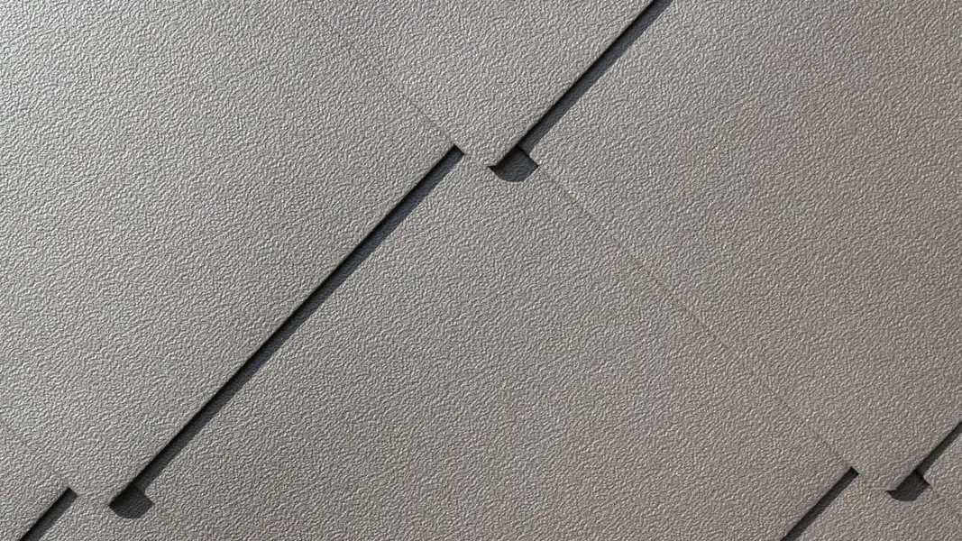 Zoom sur le losange de toiture 44x44 où l'on peut apercevoir l'aspect grainé de la teinte P.10 brun noisette se refléter dans la lumière.