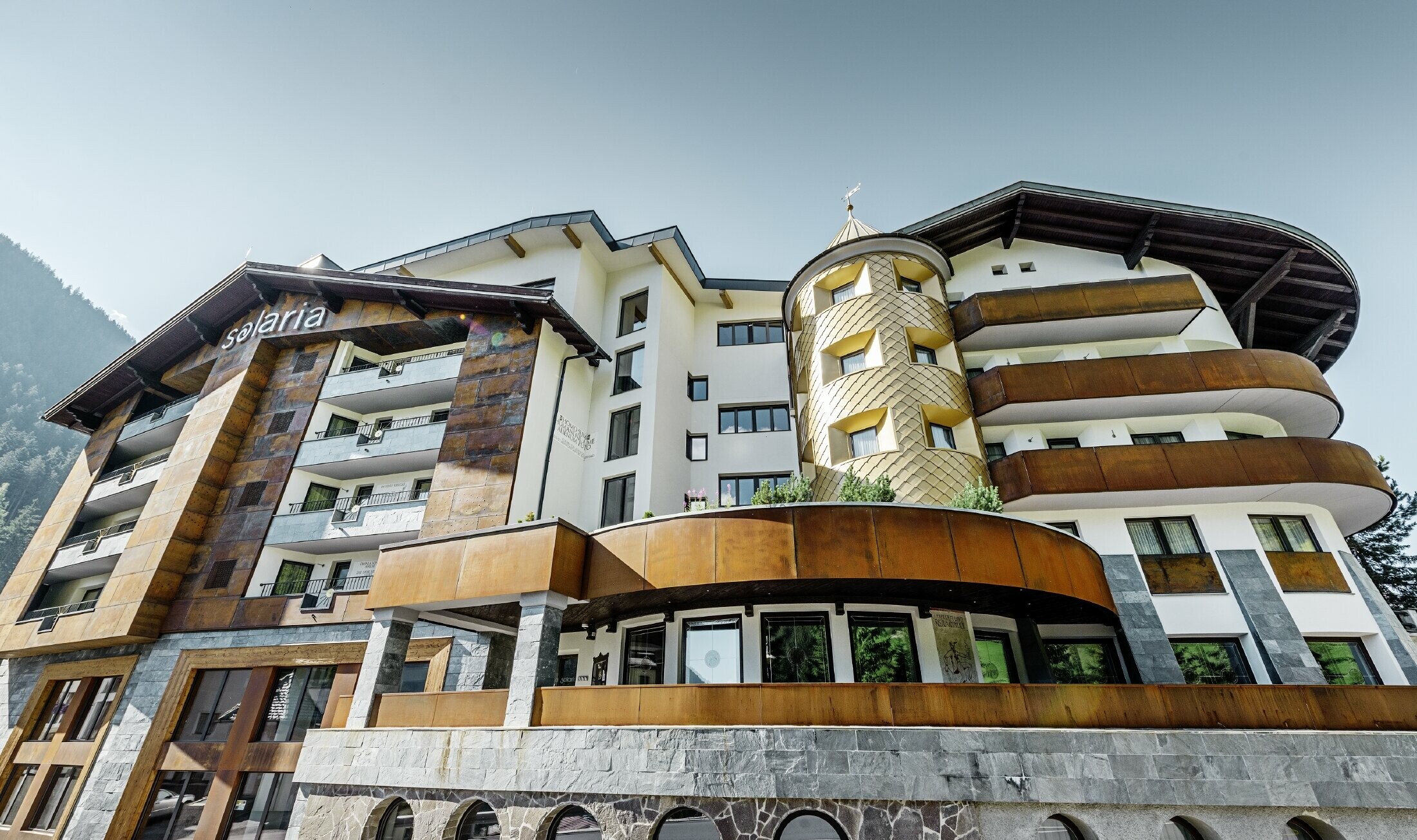 Hôtel traditionnel d’Ischgl avec balcons et façade en bois — Façade de la tour habillée de losanges en aluminium PREFA de couleur or