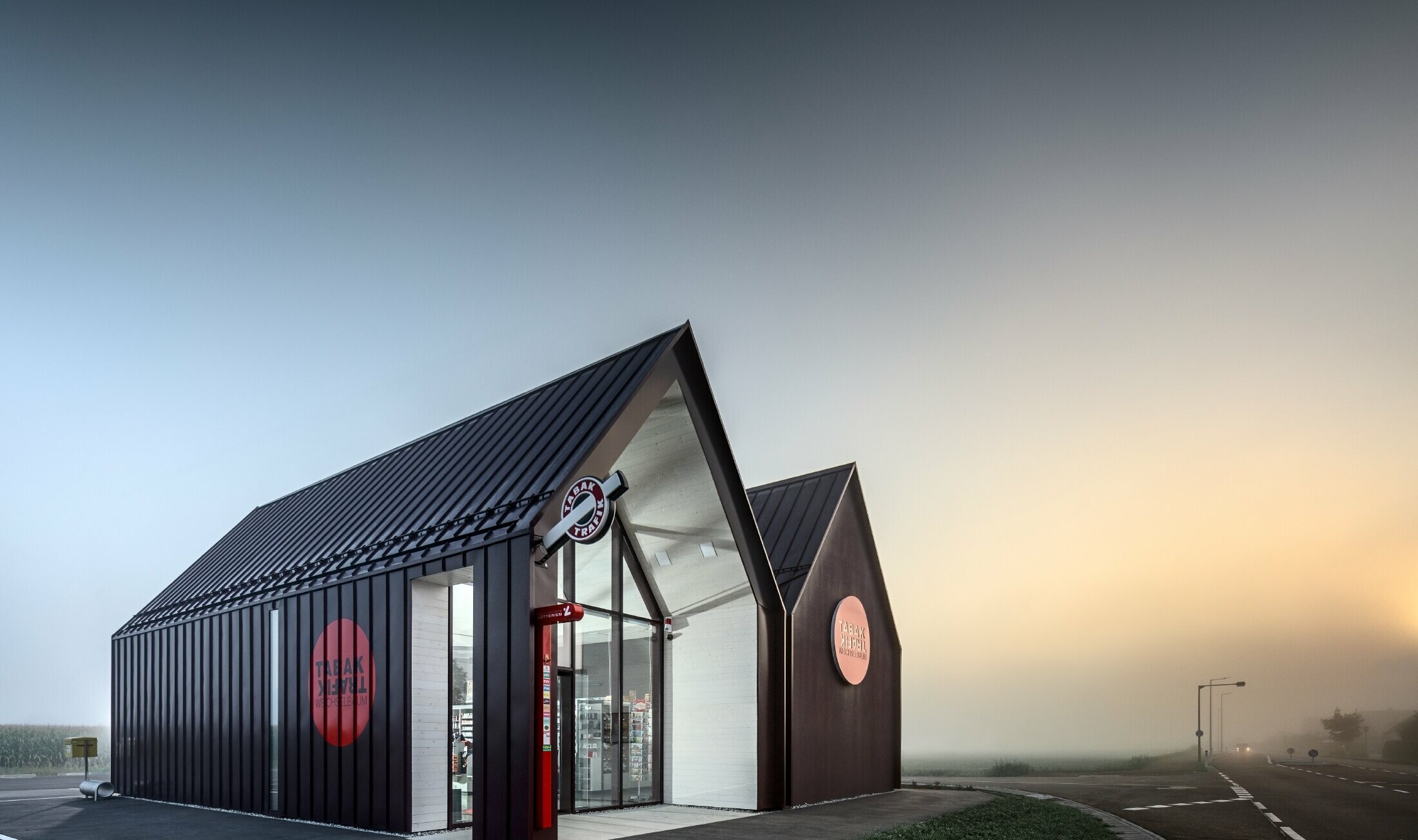 Bureau de tabac moderne au toit à deux versants sans saillie de façade — Enveloppe en aluminium PREFA à joints debout et joints angulaires rouge-noir (couleur spéciale)