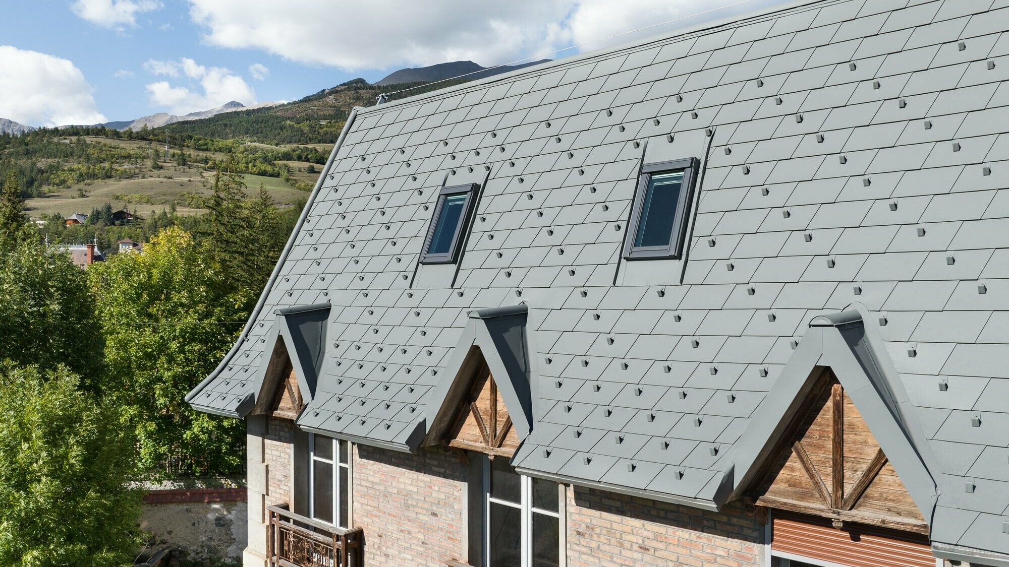 Vue prise de côté de la toiture rénovée en bardeau PREFA dans la teinte P.10 gris souris stucco